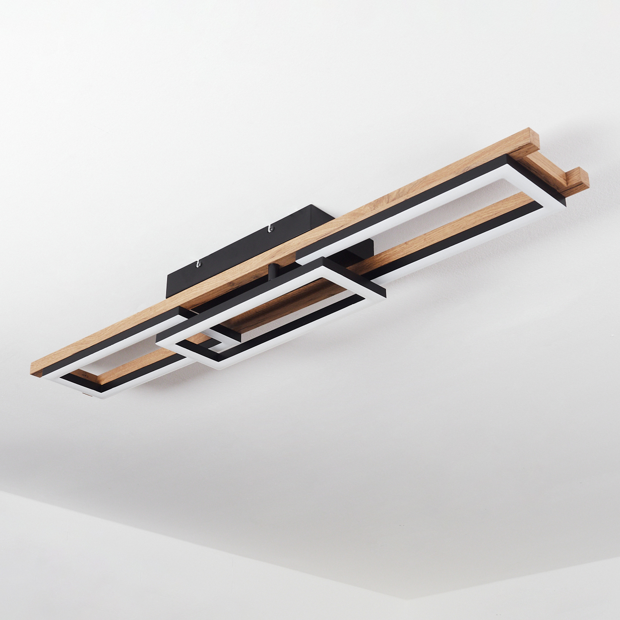 Deckenleuchte mit rechteckigen Rahmen aus Holz und Schwarz, weißer Deckenhintergrund.