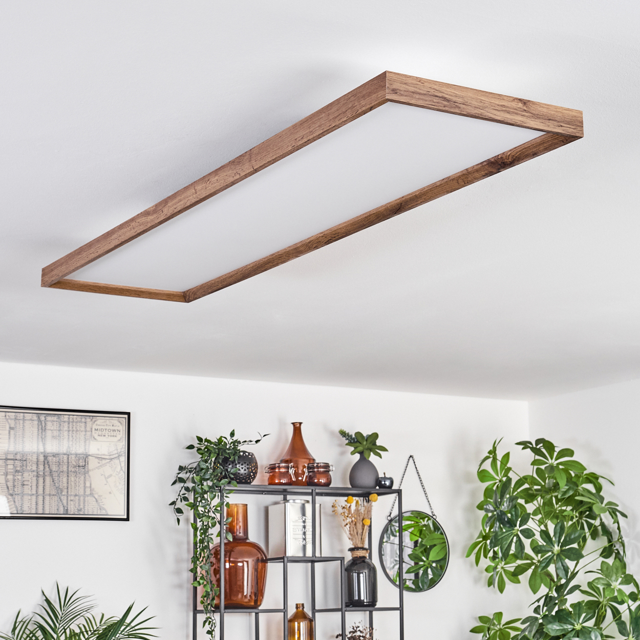 Deckenleuchte mit Holzrahmen und Lichtfeld, Pflanzen und Deko im Hintergrund.