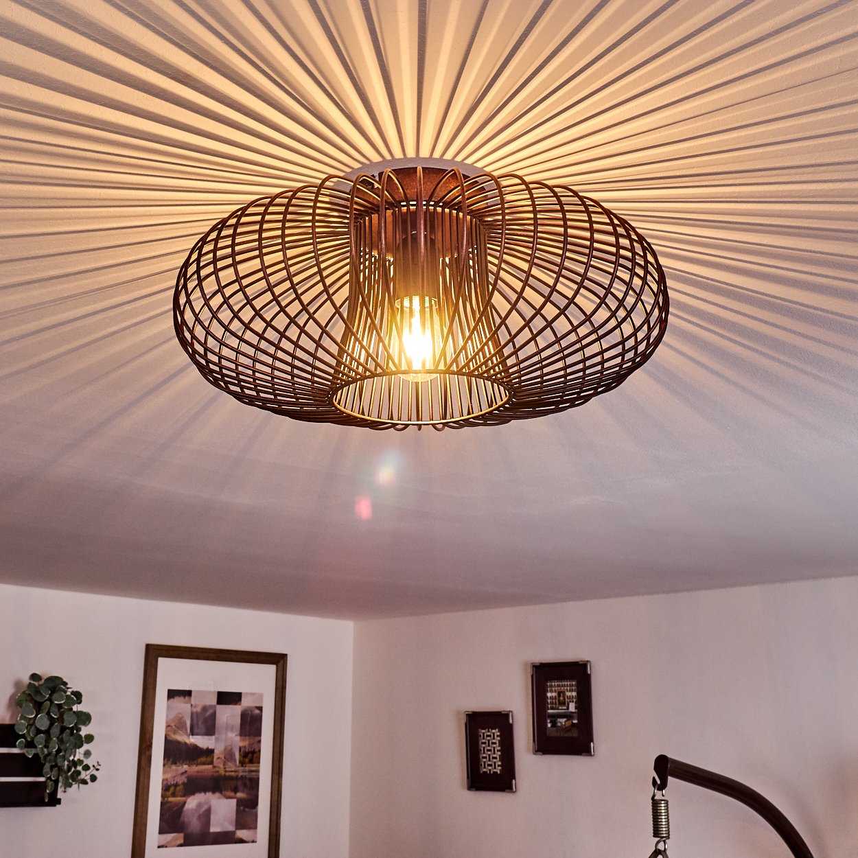 Moderne Deckenlampe mit Drahtrahmen-Design. Sichtbares Licht wird an die Decke geworfen.
