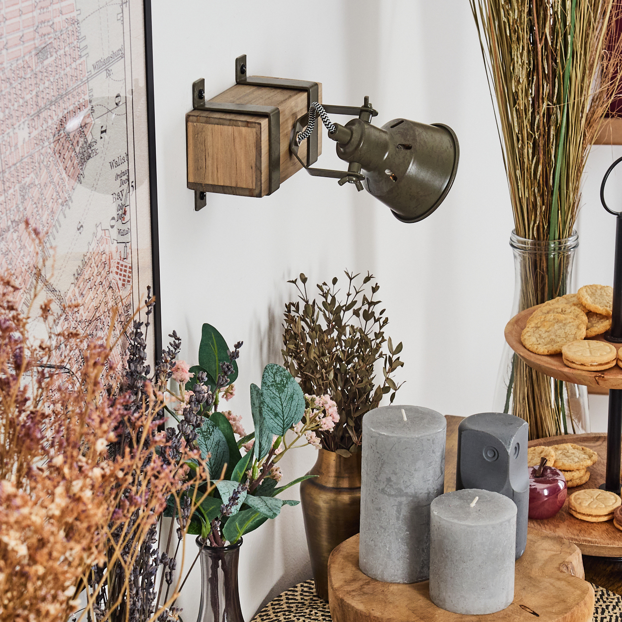 Wandlampe mit Holzsockel und olivgrünem Lampenkopf, mit Kerzen und Deko.