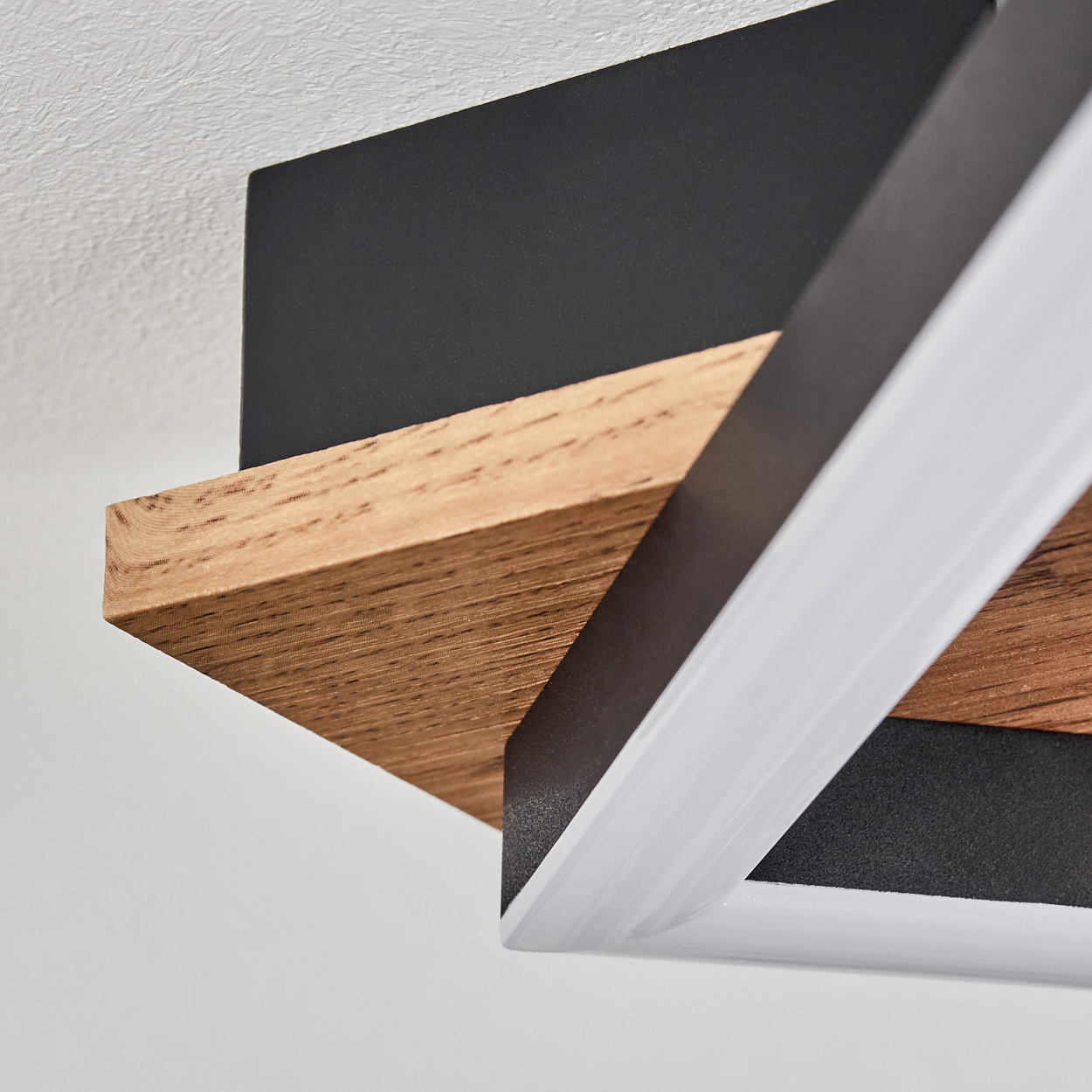 Nahaufnahme einer Deckenlampe mit Holz- und schwarzem Rahmen, weißem Innenlicht. Weißer Hintergrund.