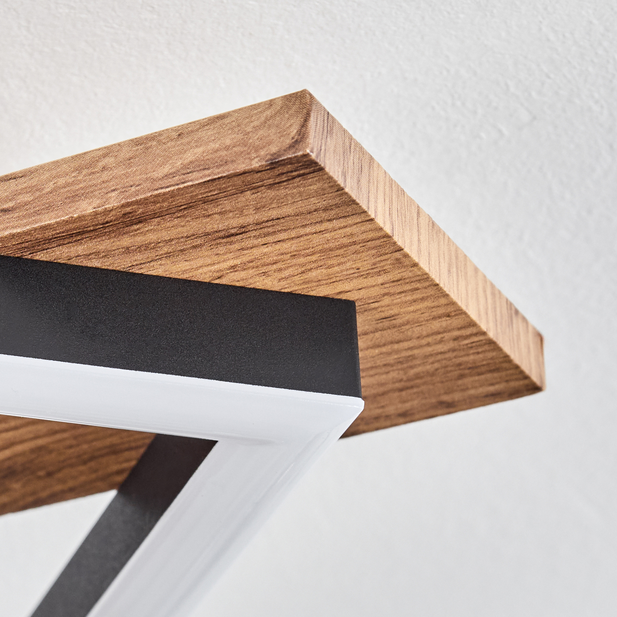 Nahaufnahme des Holzrahmens einer Deckenleuchte mit einem weißen Innenrahmen. Das Holz hat eine natürliche Maserung.