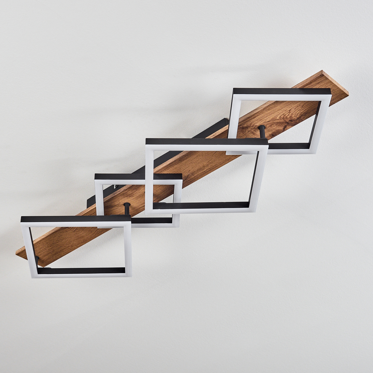 Moderne Wandlampe. Quadratische, weiß gerahmte Lichter auf Holzplanken, versetzt angeordnet. Weiße Wand.