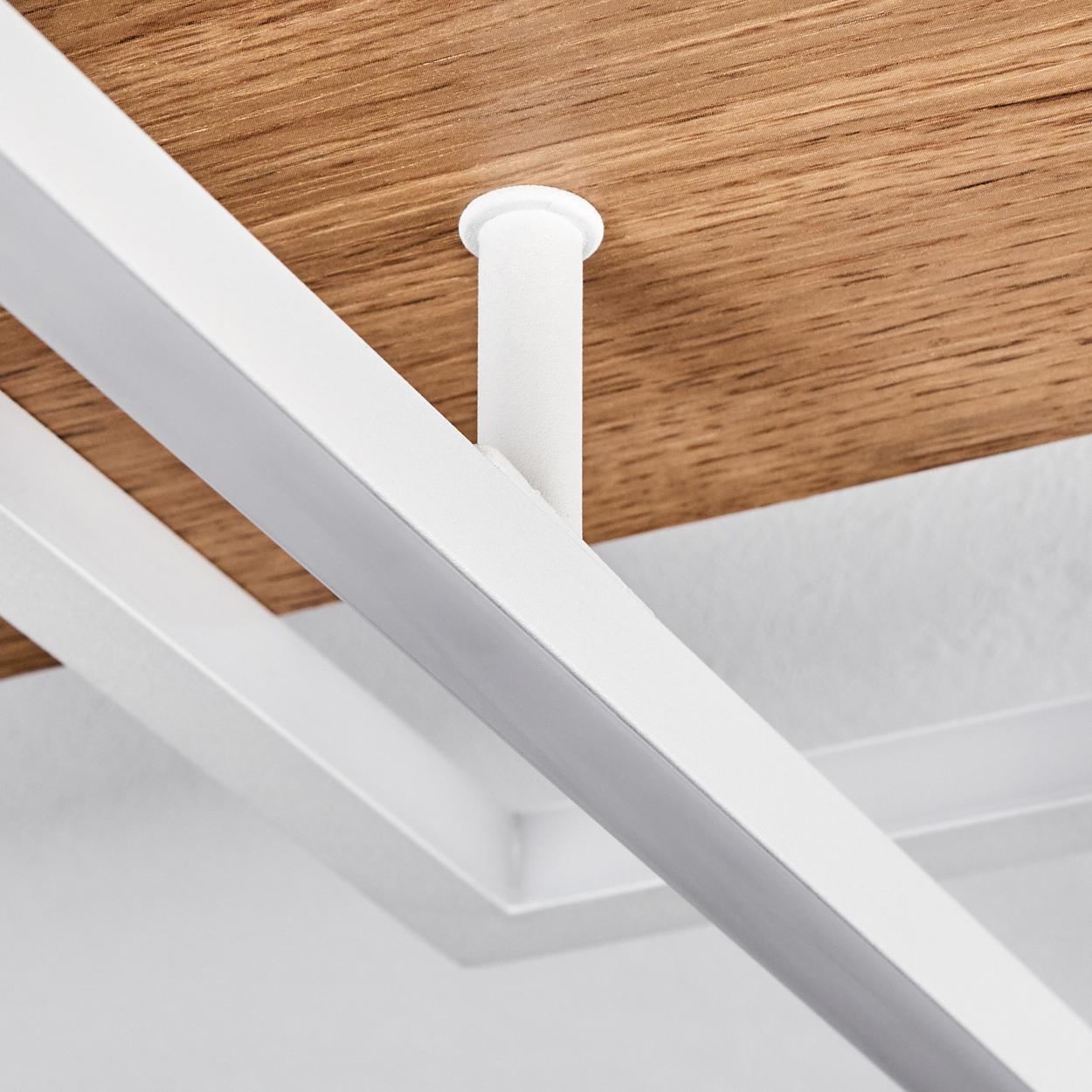 Nahaufnahme einer Deckenleuchte mit weißer Halterung und Holzpaneel. Der Hintergrund ist weiß.