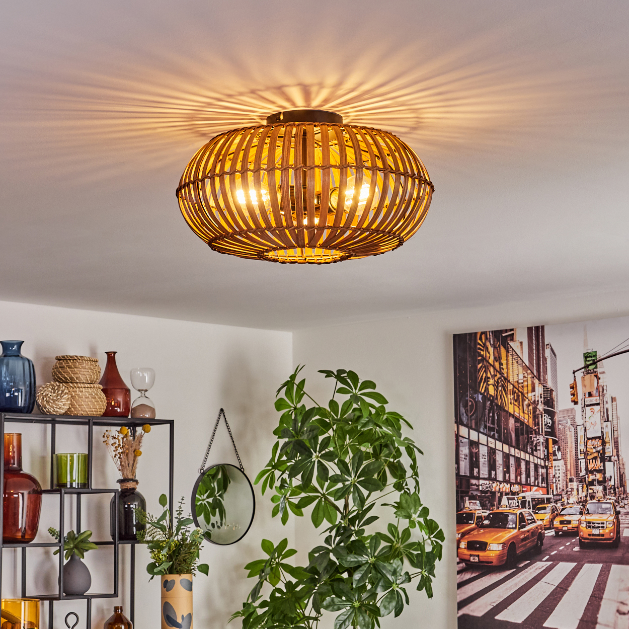 Eine Deckenlampe aus Rattan mit zwei sichtbaren Glühbirnen, die in einem Raum mit Dekoration hängt.
