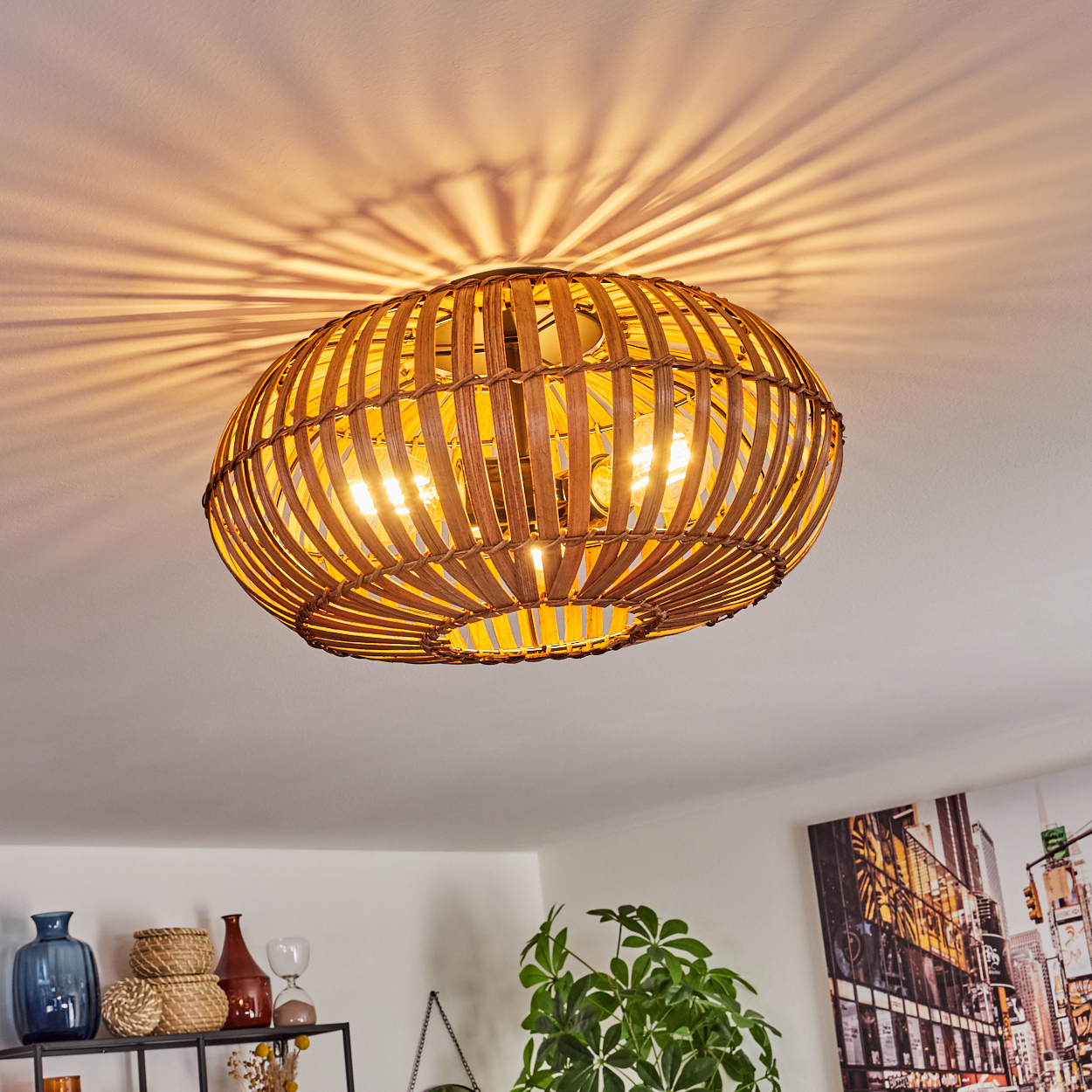 Eine Rattan-Deckenlampe mit sichtbaren Glühbirnen, die Schatten auf eine weiße Decke wirft.