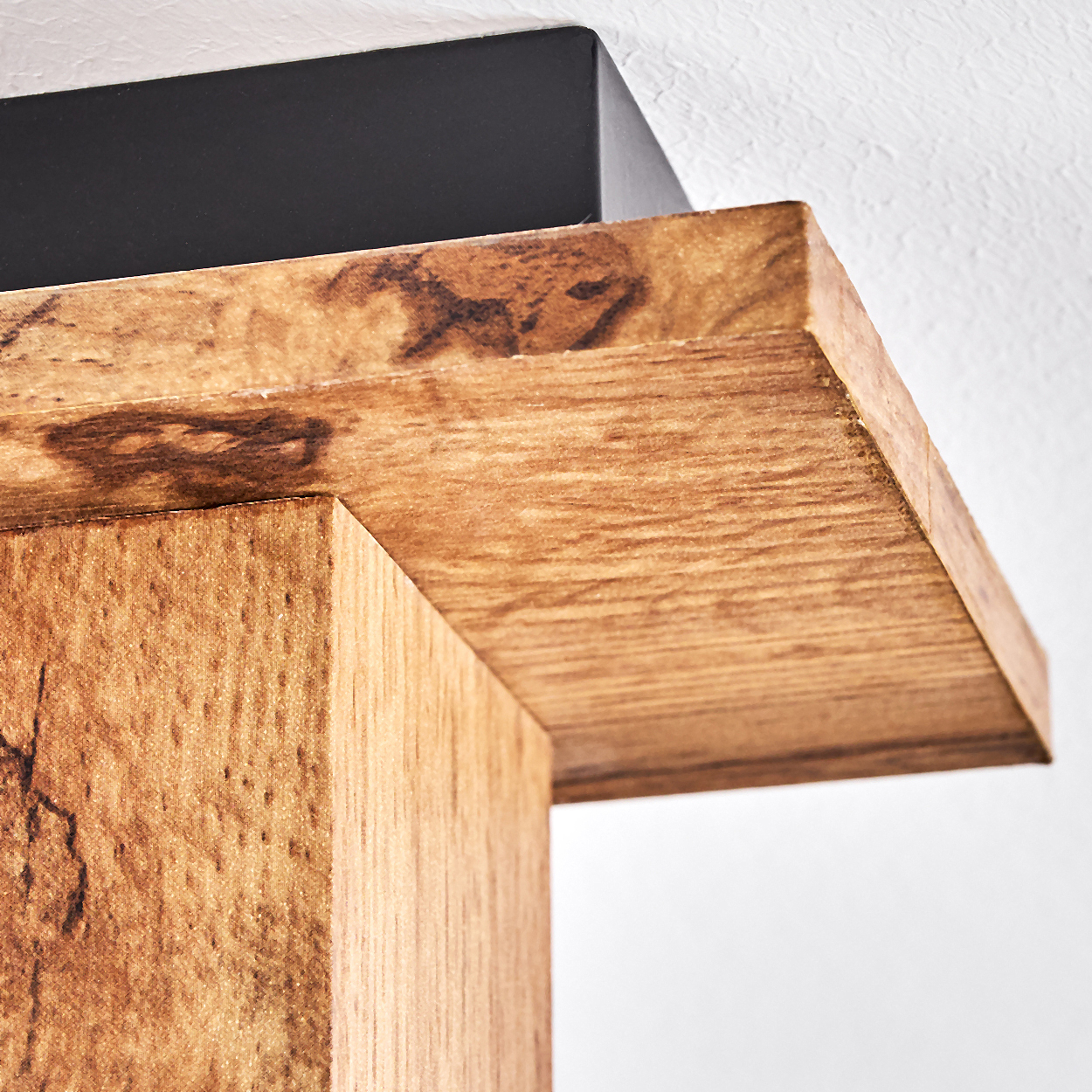 Nahaufnahme eines Holzbalkens mit schwarzen Akzenten und einem weißen Hintergrund.