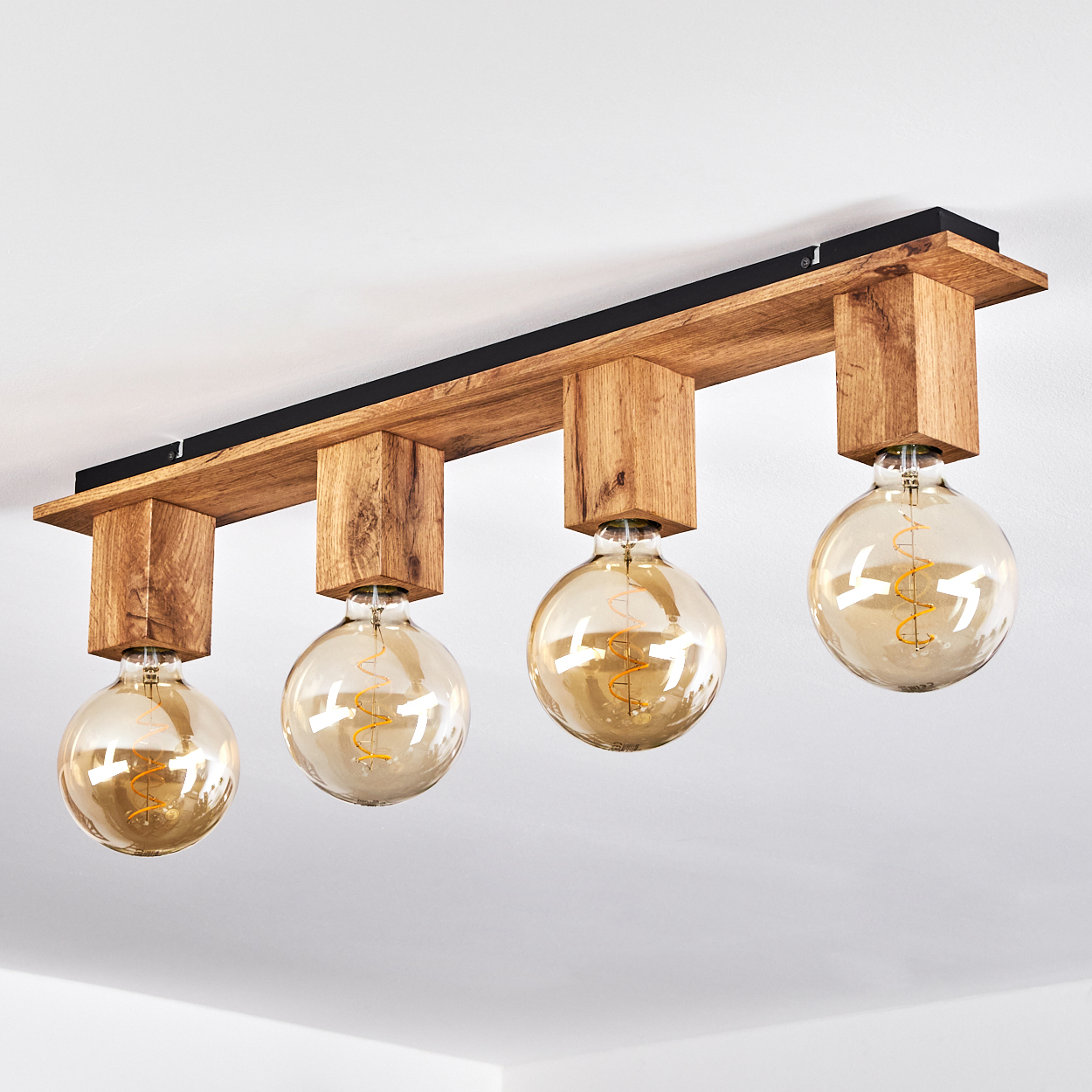 Deckenlampe mit vier Globuslampen und Holzbalken. Weiße Decke, neutraler Hintergrund.
