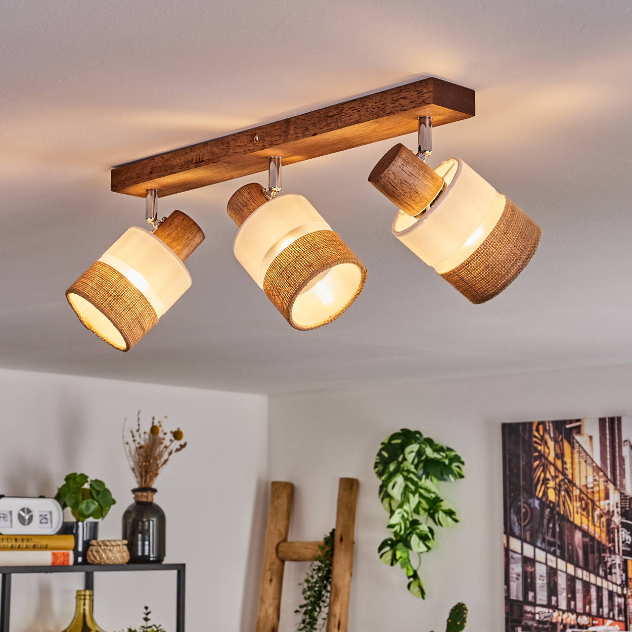 Eine Deckenleuchte mit drei Lampen, jede mit einem Holzoberteil und einem burlapbedeckten Schirm.