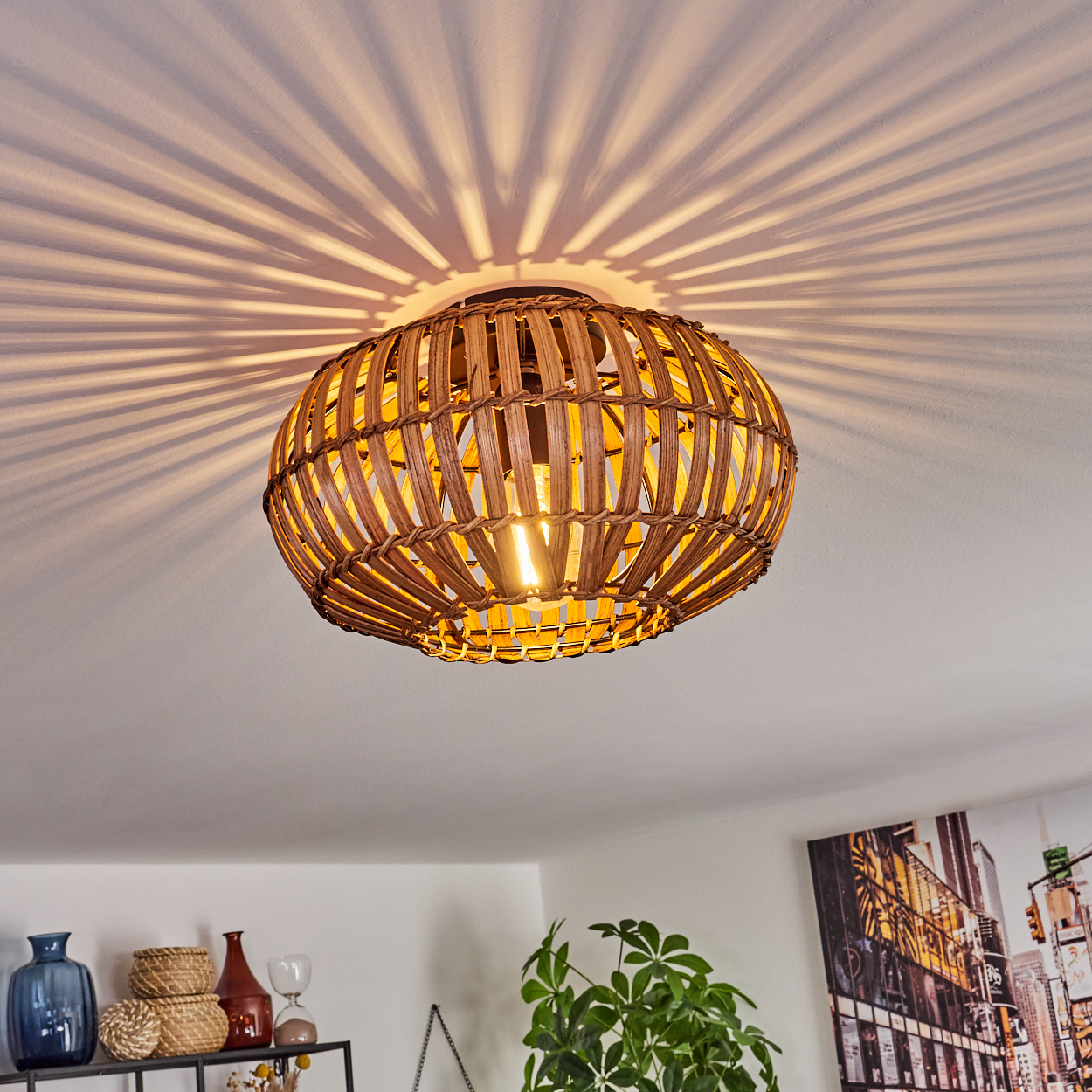 Eine gewebte Deckenlampe aus Rattan, die ein radiales Lichtmuster an die Decke wirft.