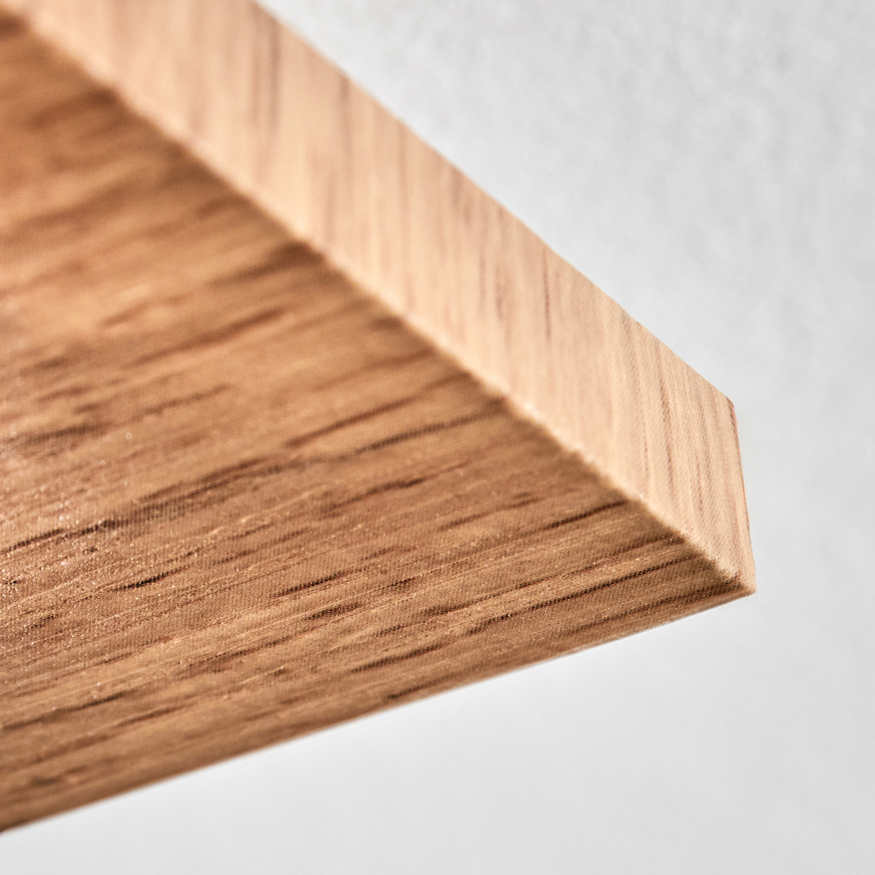 Nahaufnahme einer Holzplanke mit sichtbarer Maserung. Das Holz ist hellbraun. Der Hintergrund ist weiß.