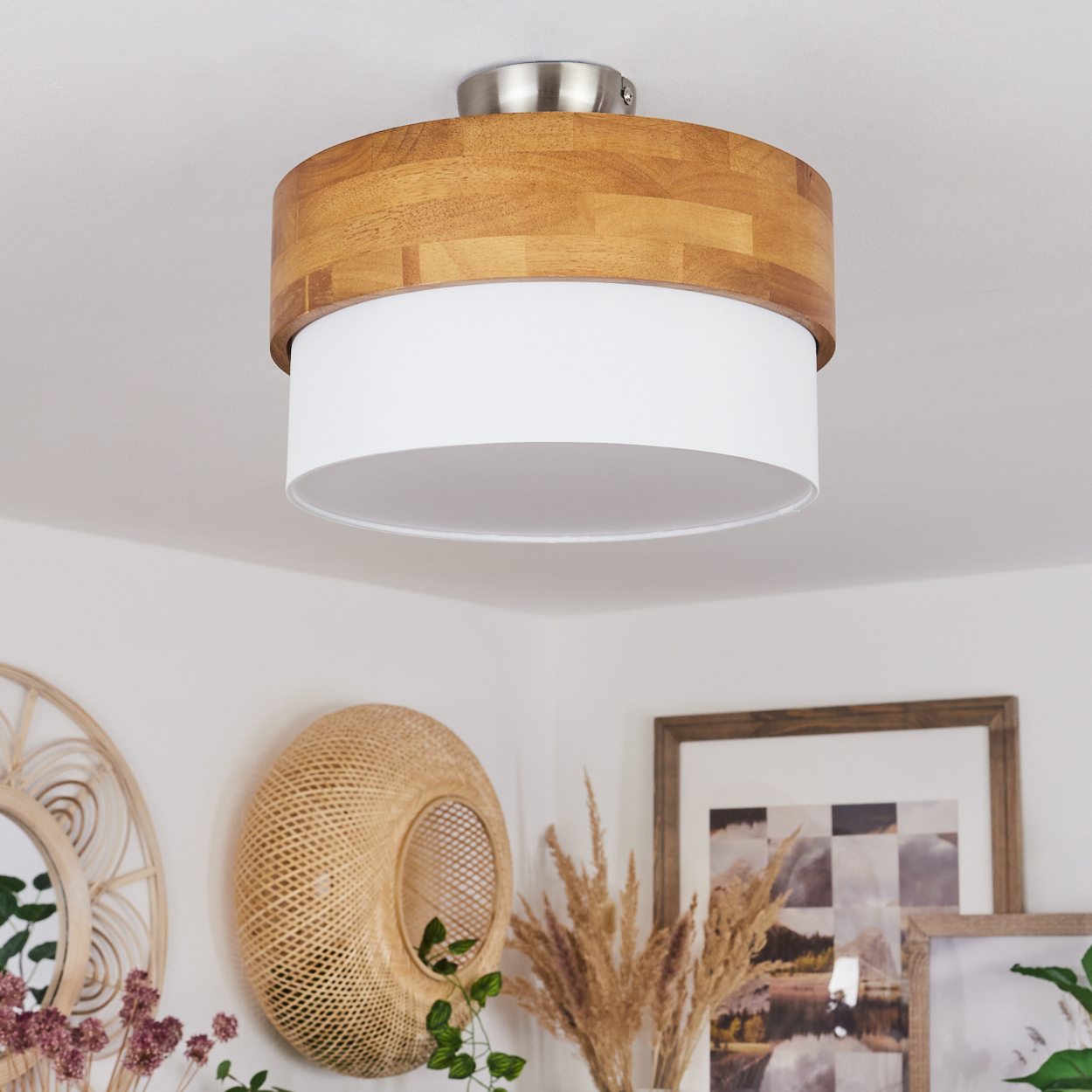 Eine Deckenlampe aus Holz und Weiß in einem Raum mit gerahmter Kunst und Dekorationsartikeln.