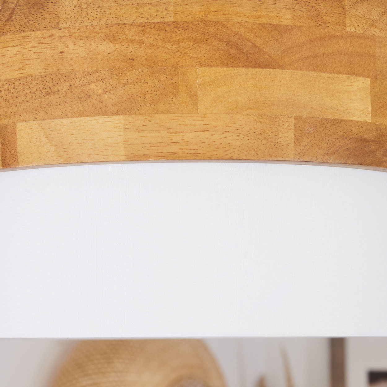 Nahaufnahme einer Deckenlampe aus Holz und Weiß. Der Holzteil ist oben.