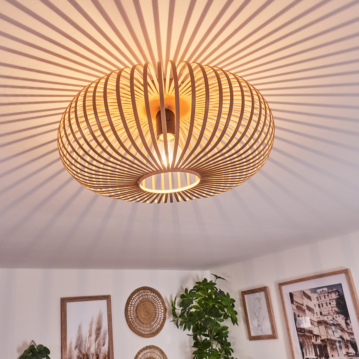 Deckenleuchte mit Holzlamellen, die ein Schattenmuster an der Decke erzeugen.