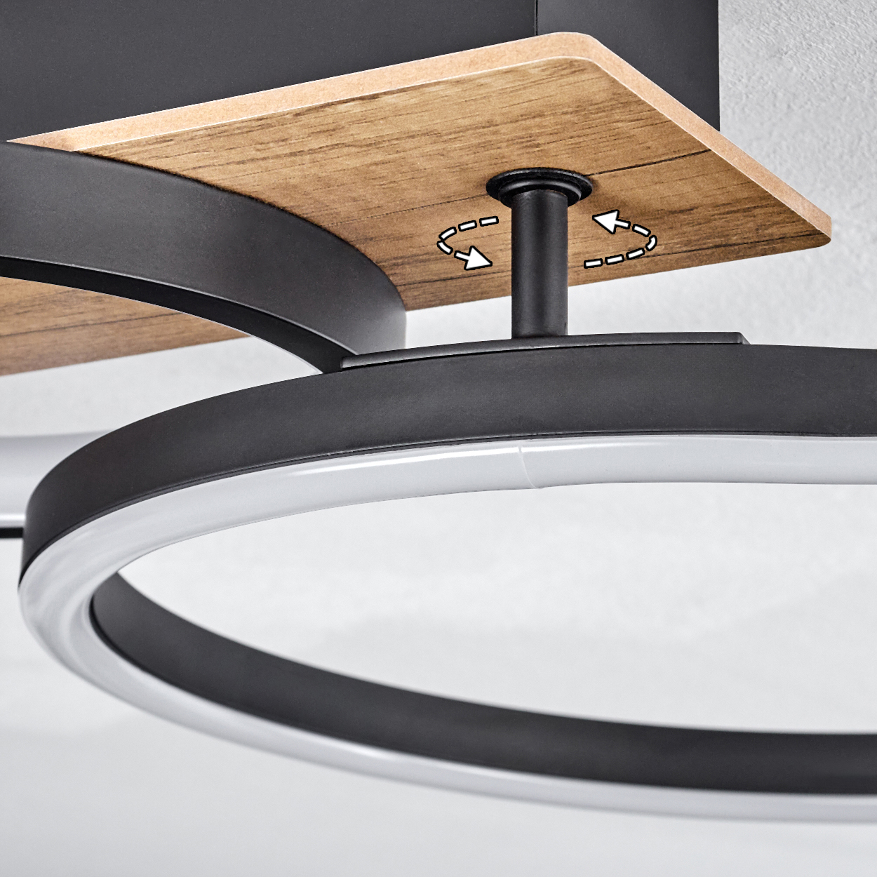 Nahaufnahme einer Deckenlampe mit Holzsockel und schwarz-weißen Ringen, die das Design und die Struktur hervorhebt.