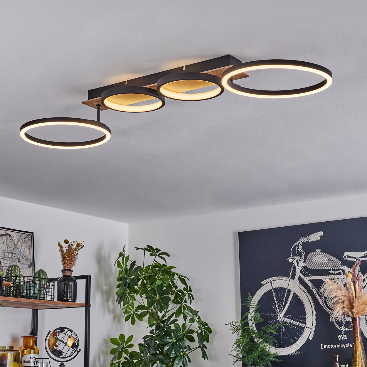 Deckenlampe mit drei schwarz-weißen Ringen an Holz, mit eingerichtetem Raum im Hintergrund.