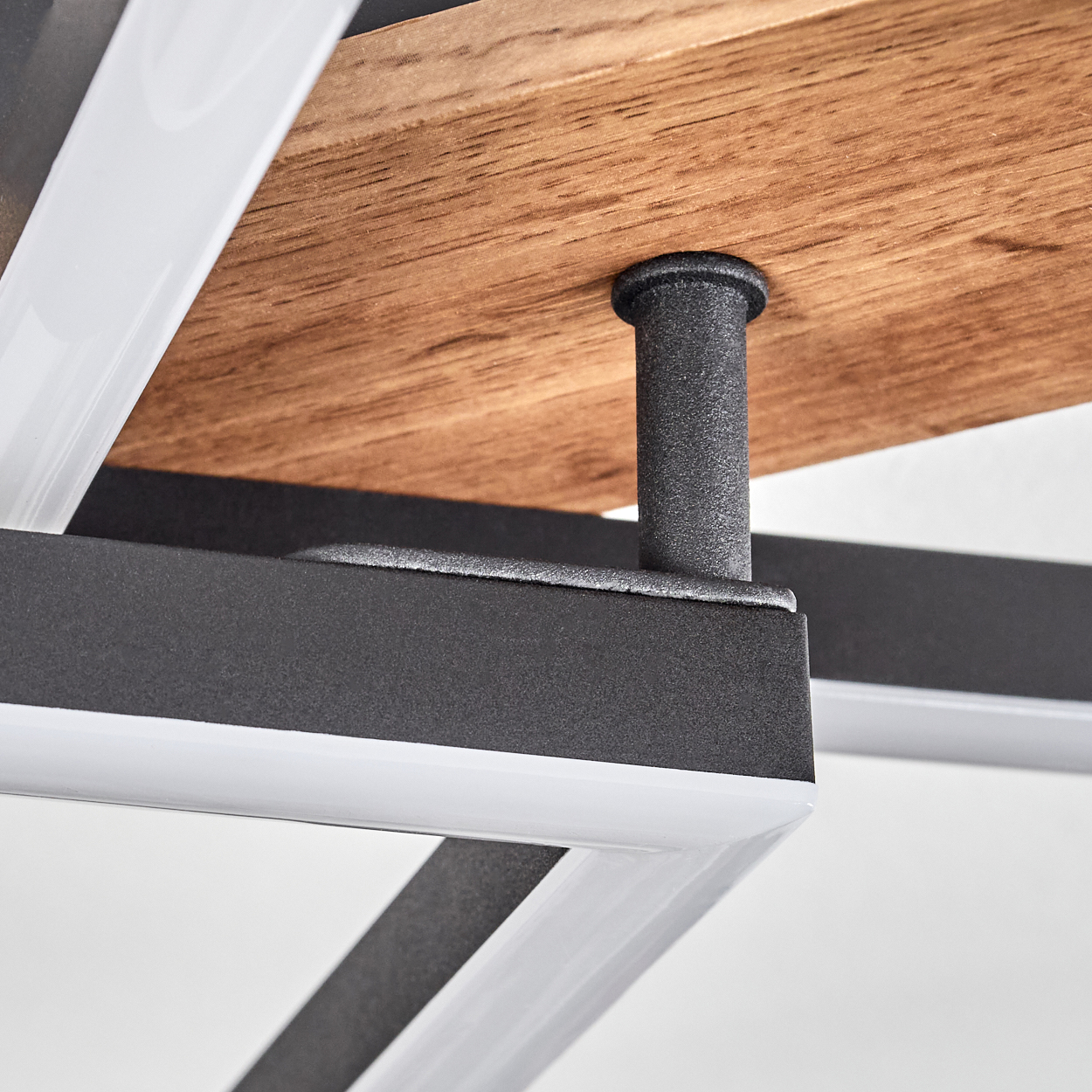 Nahaufnahme einer Deckenlampe mit Holz- und schwarzem Rahmen, die Verbindungsdetails zeigt.