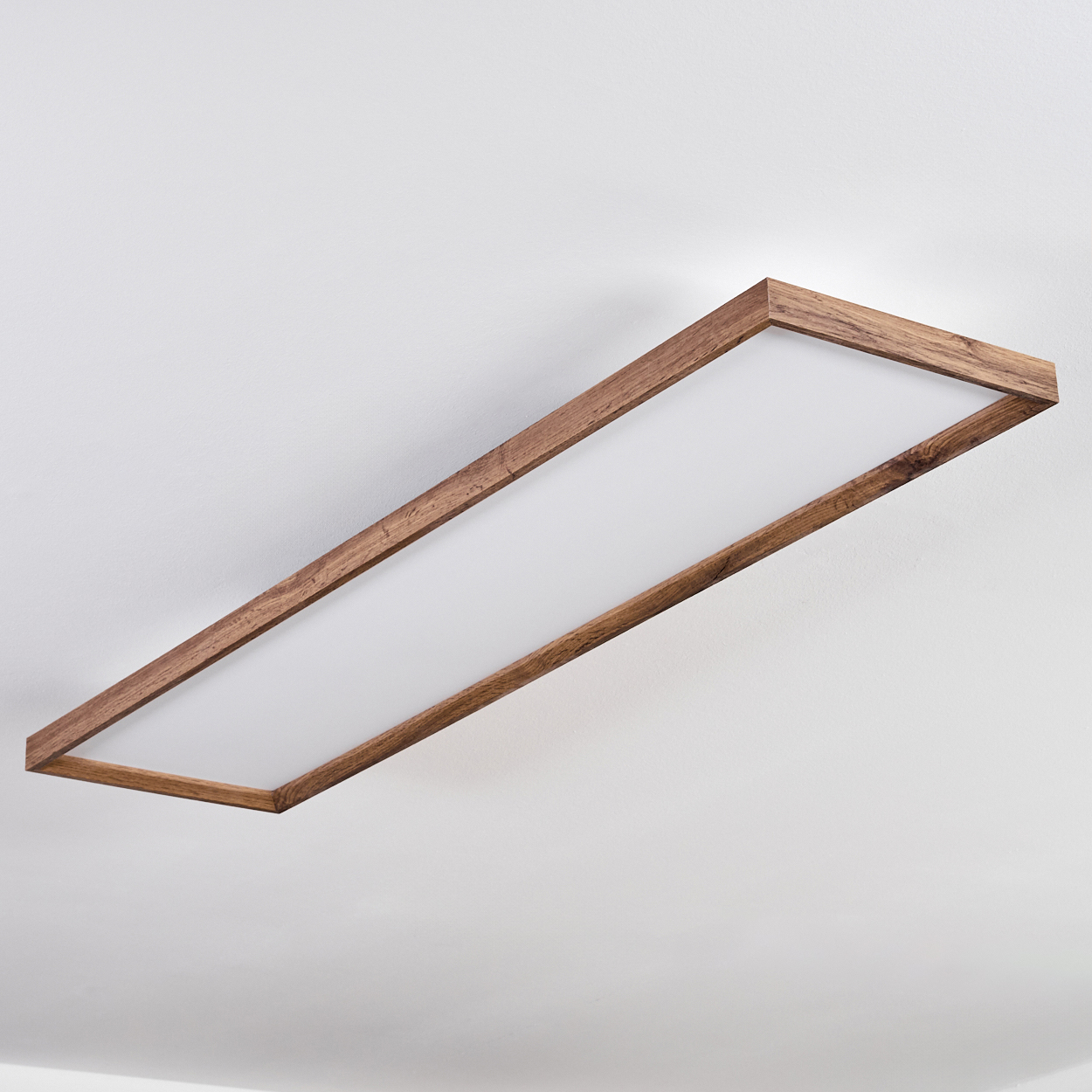 Eine rechteckige Deckenleuchte mit Holzrahmen und weißer Lichtquelle. Sie wird aus einem niedrigen Winkel betrachtet.