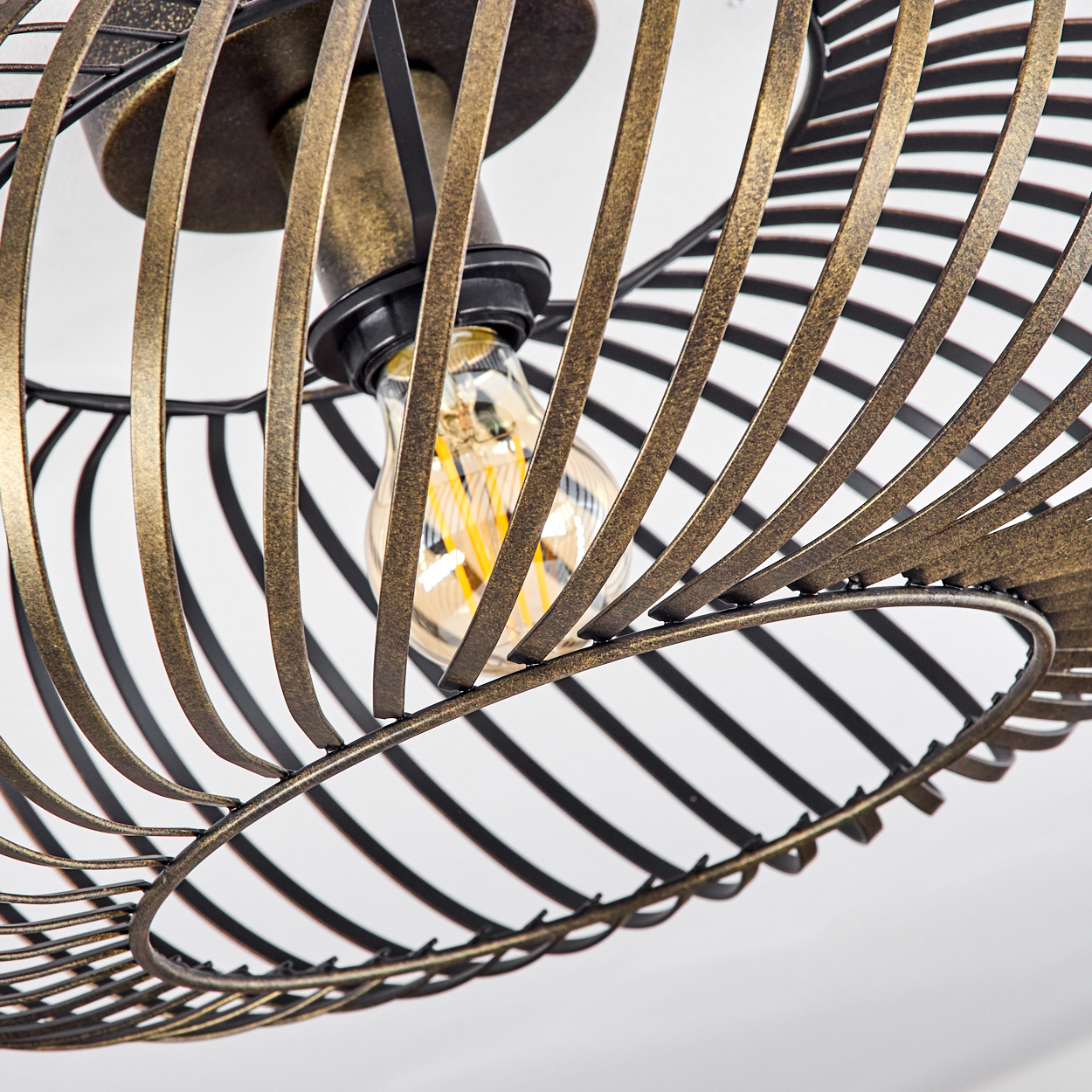 Nahaufnahme einer bronzefarbenen, spiralförmigen Deckenlampe, die die Glühbirne und das Metalldesign der Struktur zeigt.