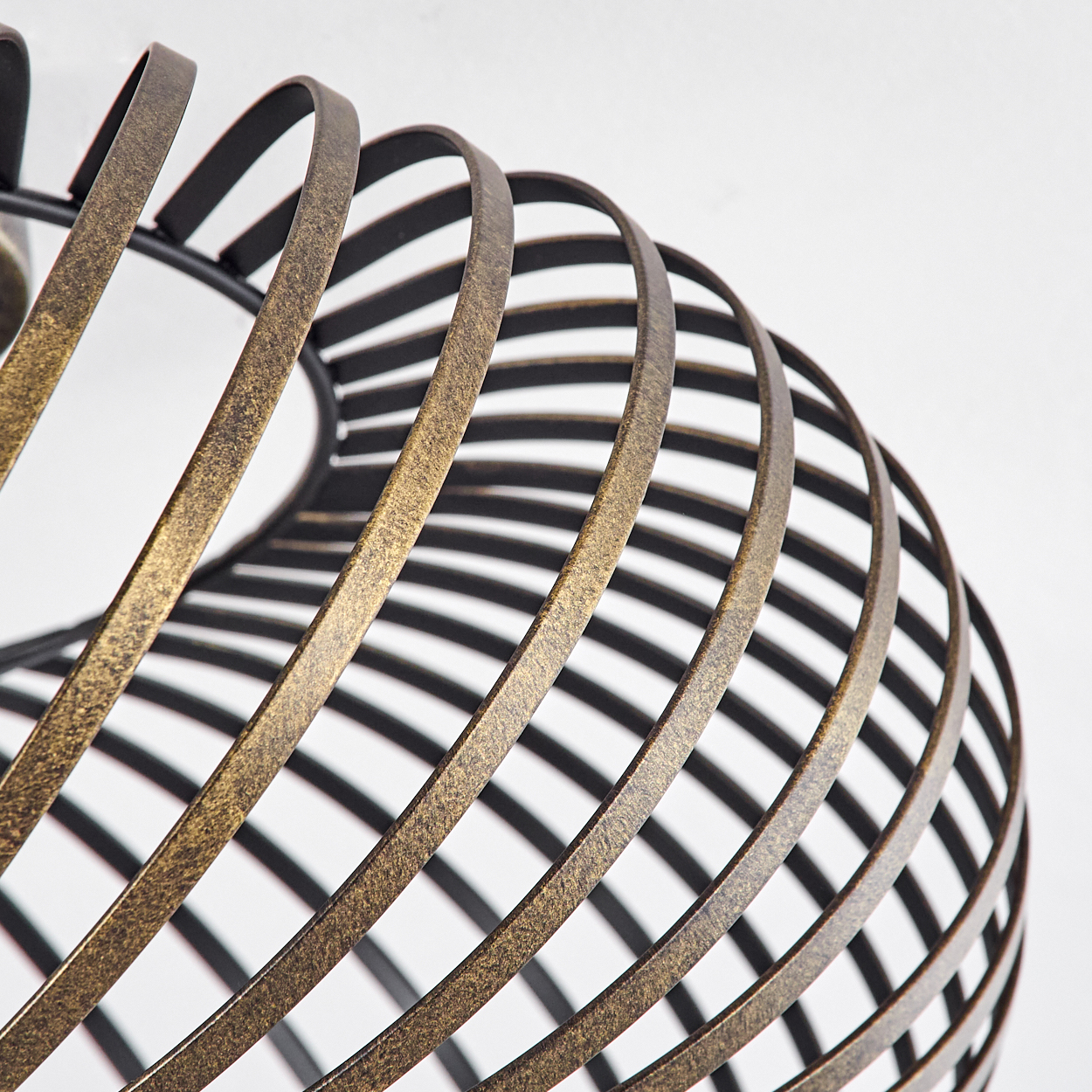 Nahaufnahme der bronzefarbenen Spiralstruktur einer Deckenlampe, die die Metallstäbe und ihre Anordnung zeigt.
