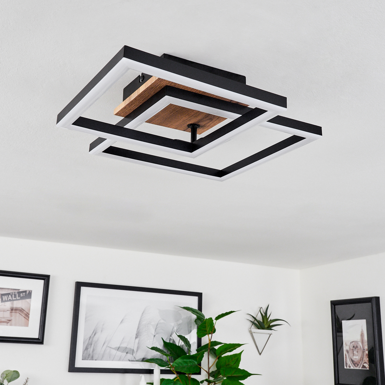 Eine moderne Deckenlampe mit geometrischem Design, schwarz-weiße Quadrate mit Holzmitte, in einem Raum.