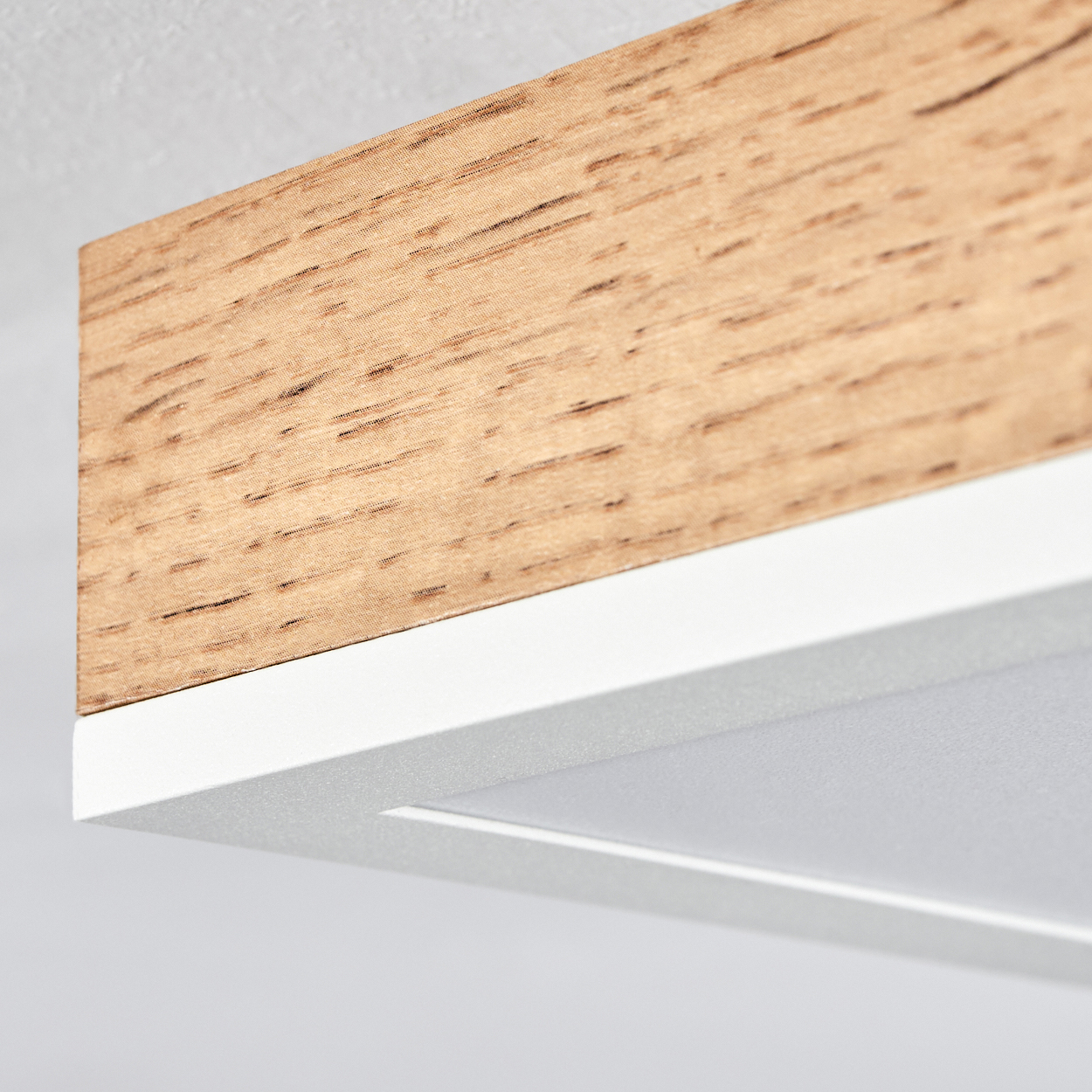 Nahaufnahme einer modernen Deckenleuchte aus Holz und Weiß.
