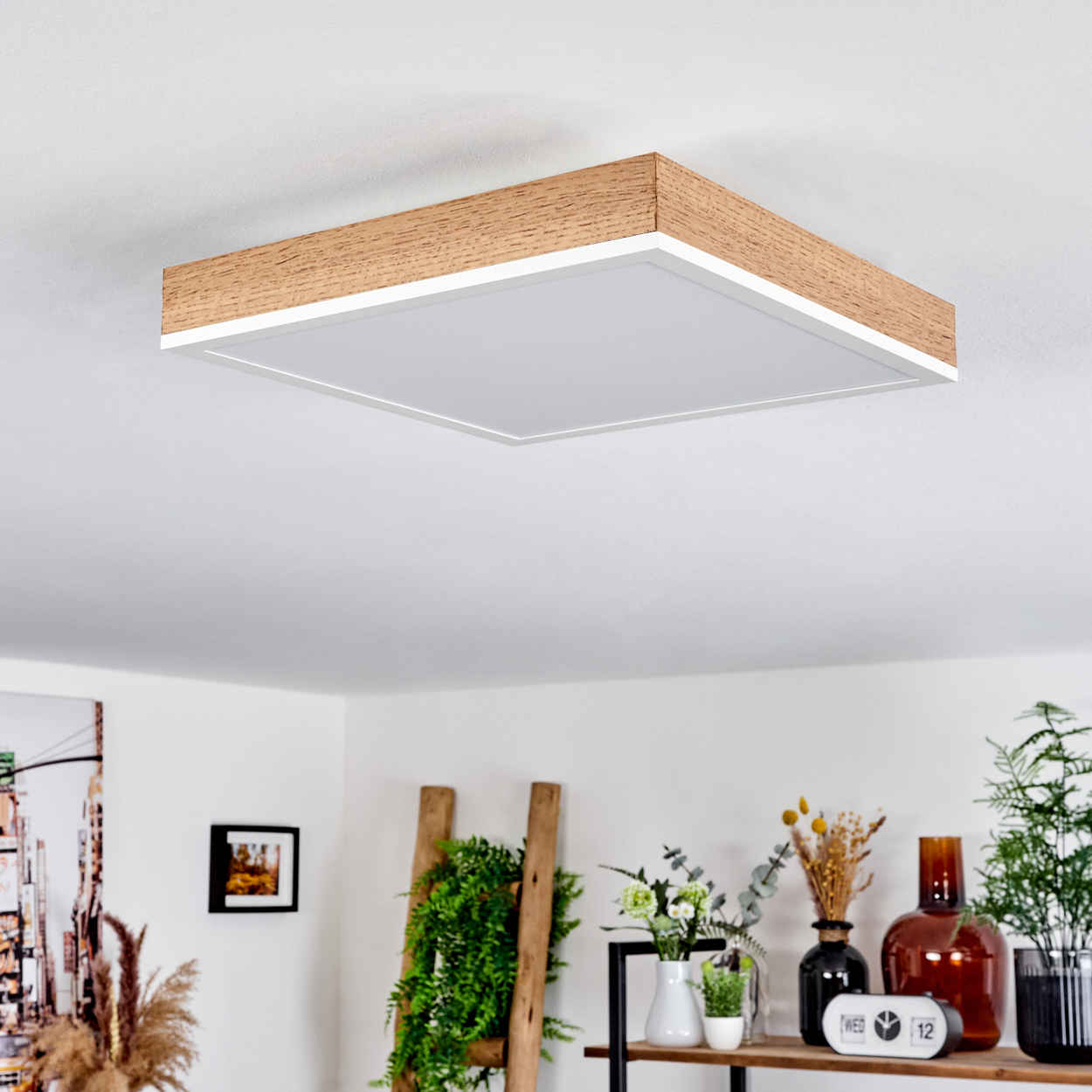 Quadratische Deckenleuchte in einem Wohnzimmer mit Pflanzen und Dekoration.