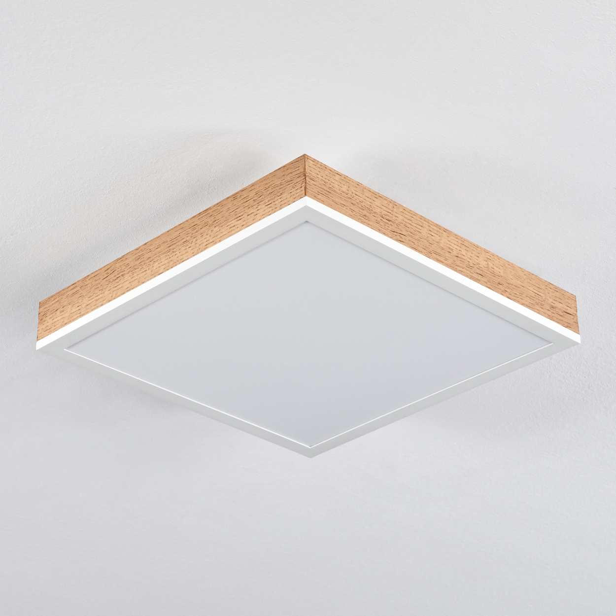 Quadratische Deckenleuchte mit Holzverkleidung, Nahaufnahme an weißer Decke.