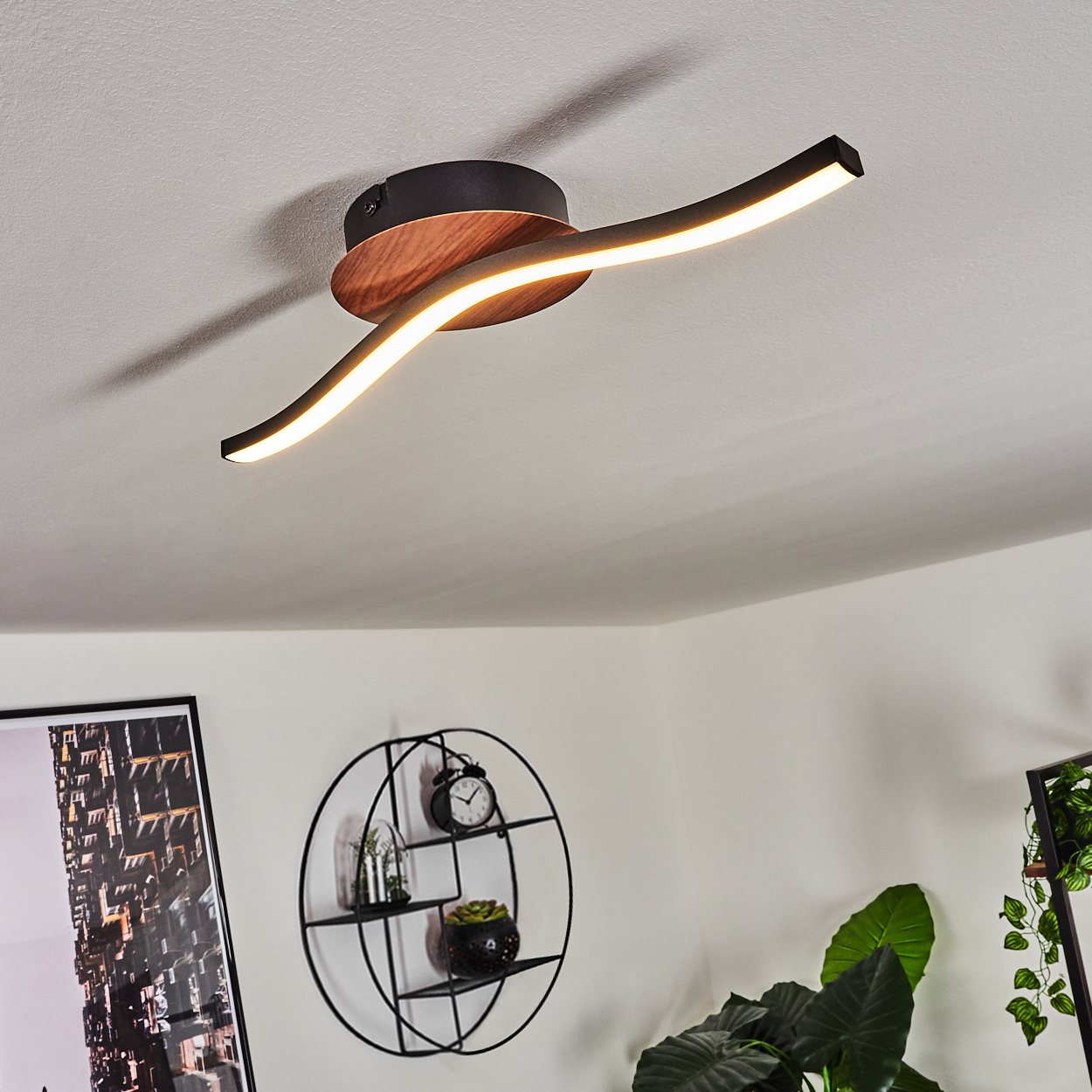 Moderne Deckenleuchte mit Holzsockel und gebogenen schwarzen Armen, im Wohnzimmer.