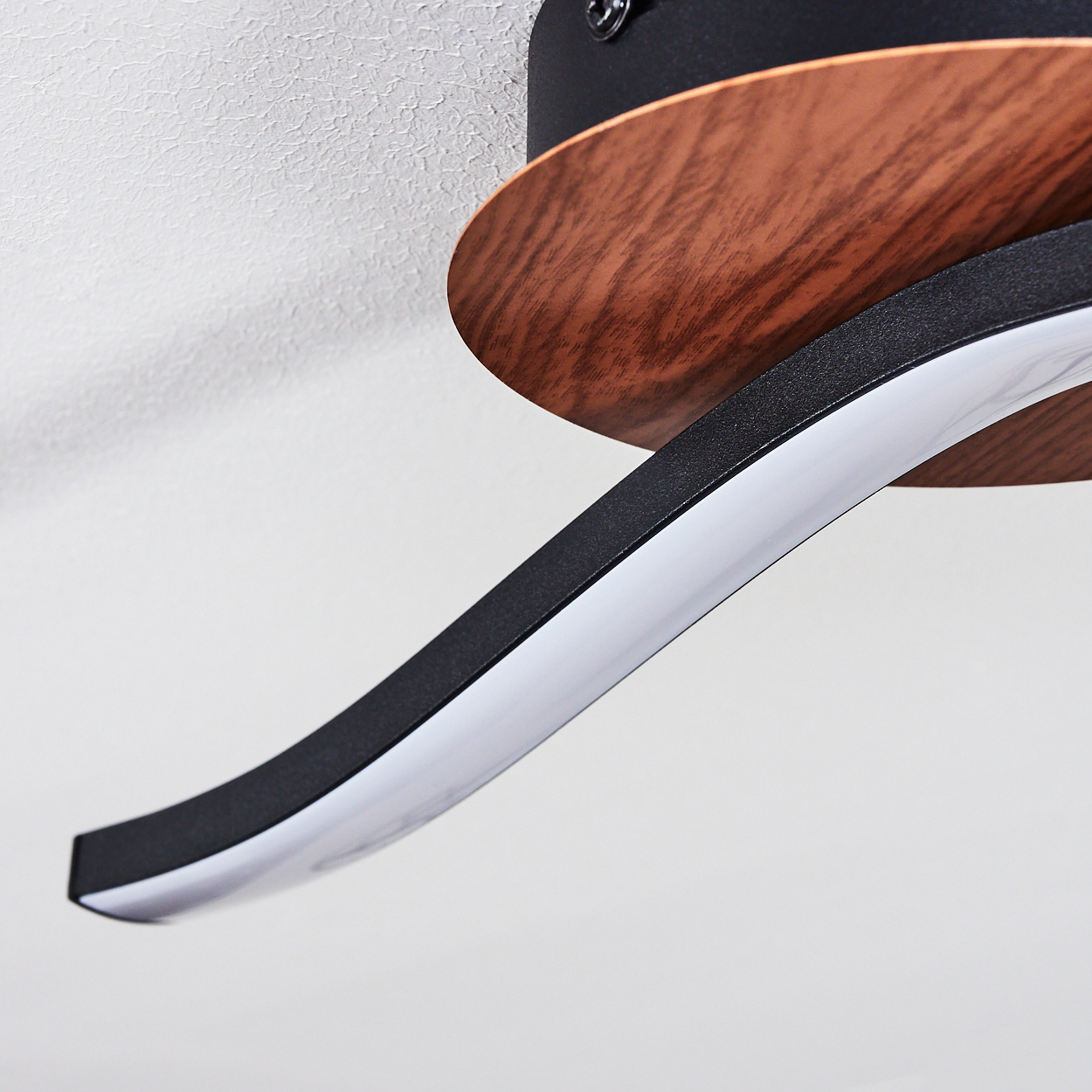 Nahaufnahme einer Deckenleuchte. Das Licht hat ein schwarzes, Holz- und weißes Design.
