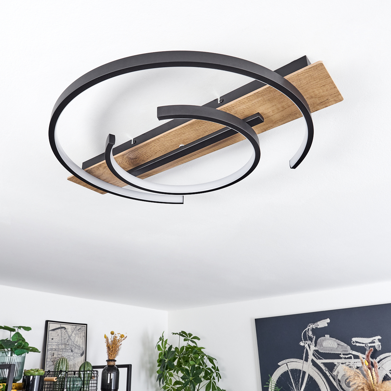 Deckenlampe mit Holzsockel, schwarzen Metallelementen und Lichtleiste, von unten.