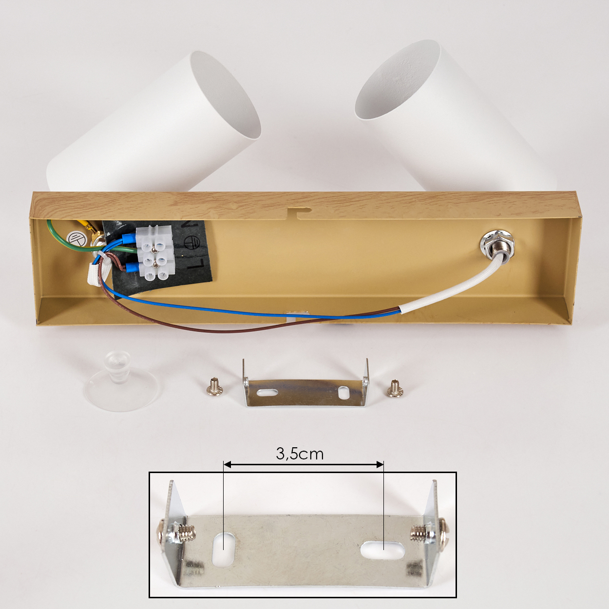 Zerlegte Deckenlampe mit weißen Zylindern, braunem Sockel und Montagematerial.