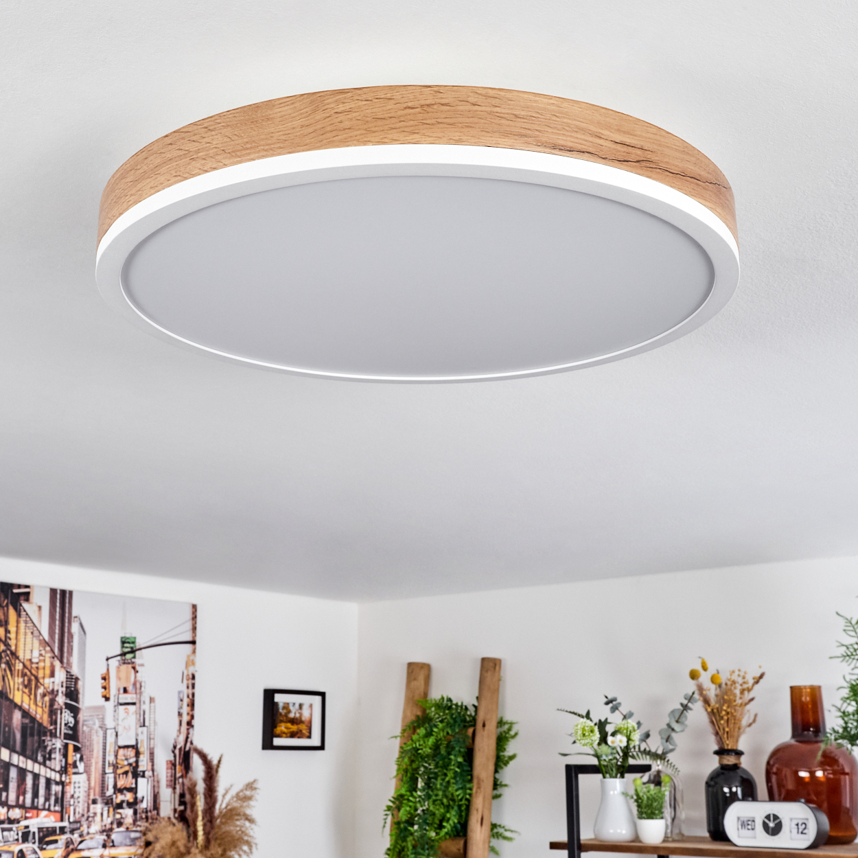Runde Deckenlampe mit Holzmaserung und weißer Mitte, an einer weißen Decke.