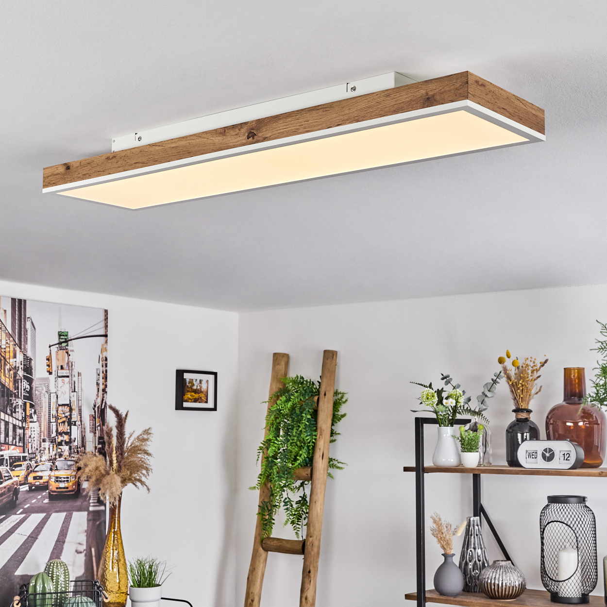 Ein Raum mit Deckenleuchte, Leiter und Dekoration. Das Licht ist rechteckig mit Holz- und weißem Finish.