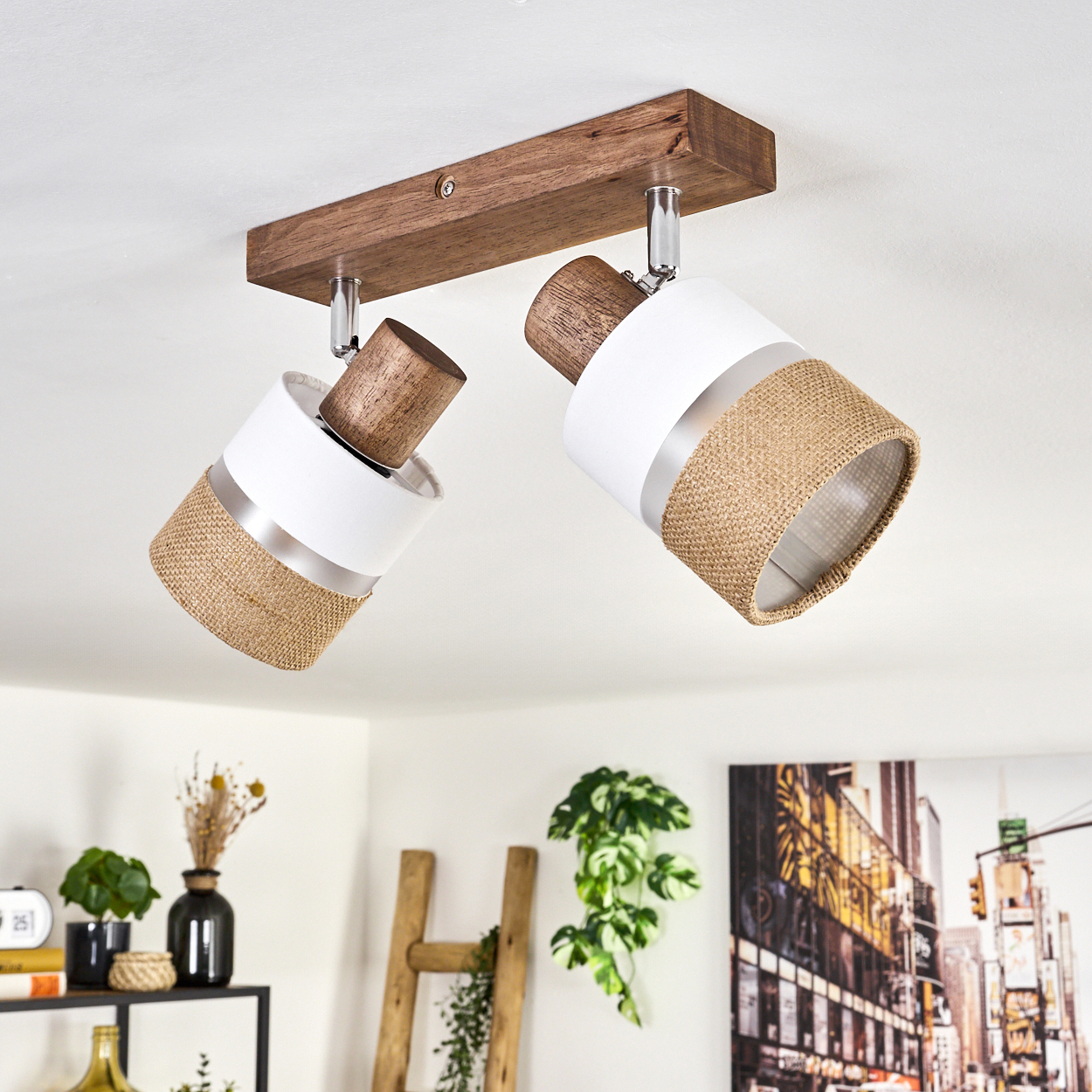Zwei weiße und beige Lampen an einem Holzbalken. Ein Raum mit Pflanzen und Möbeln ist im Hintergrund.