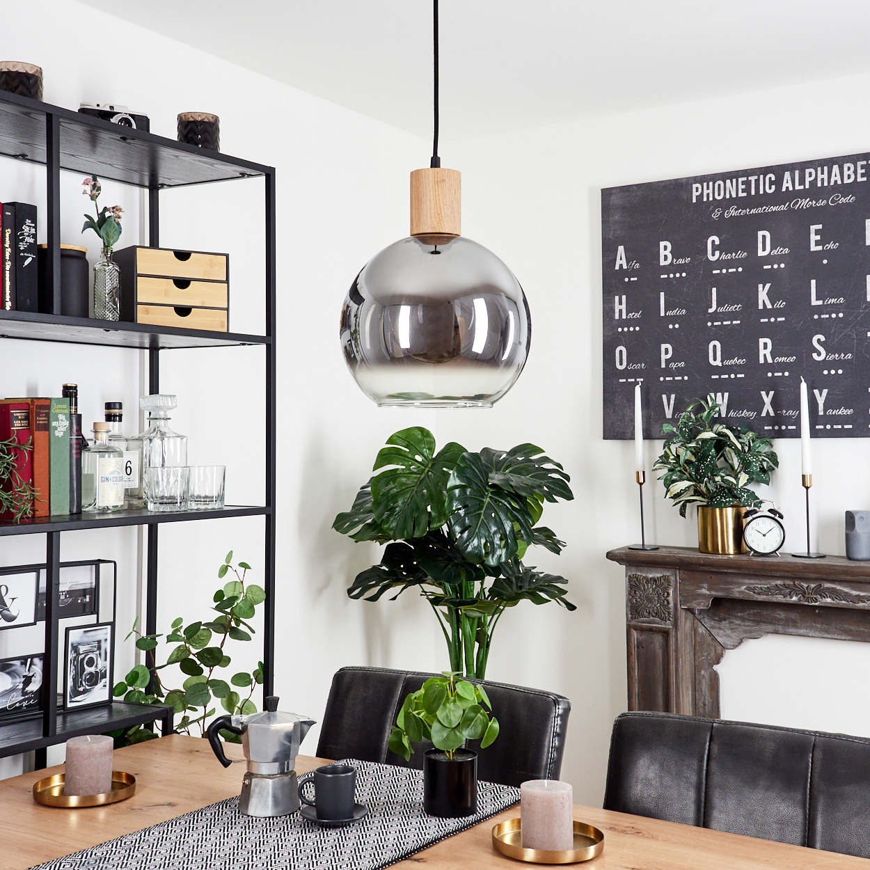 Esszimmer mit Hängelampe, einer Tafel und verschiedenen dekorativen Gegenständen.