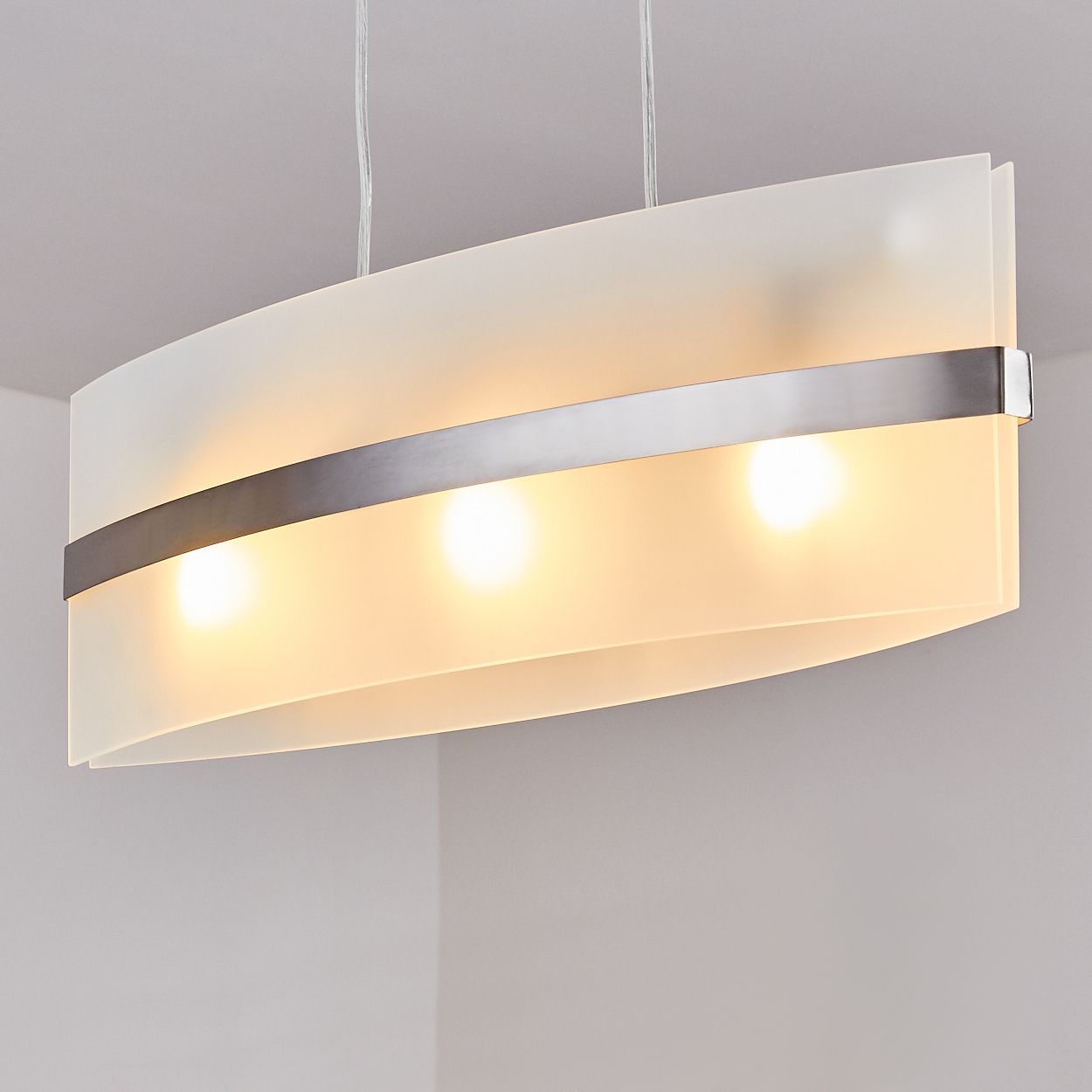 Eine weiße Metall-Hängelampe mit drei Lichtern, die von der Decke hängt.