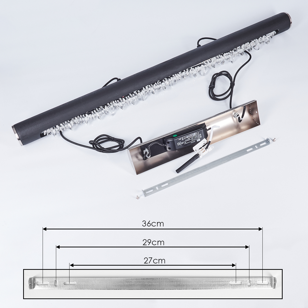 Eine Draufsicht auf eine schwarze Leuchte mit Kristallakzenten, ausgelegten Komponenten und Maßdetails.