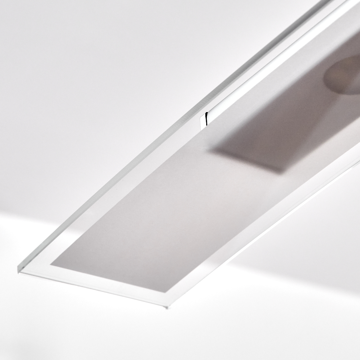 Nahaufnahme einer rechteckigen Lampe mit mattierter Glasoberfläche, zeigt Innenbeleuchtung.