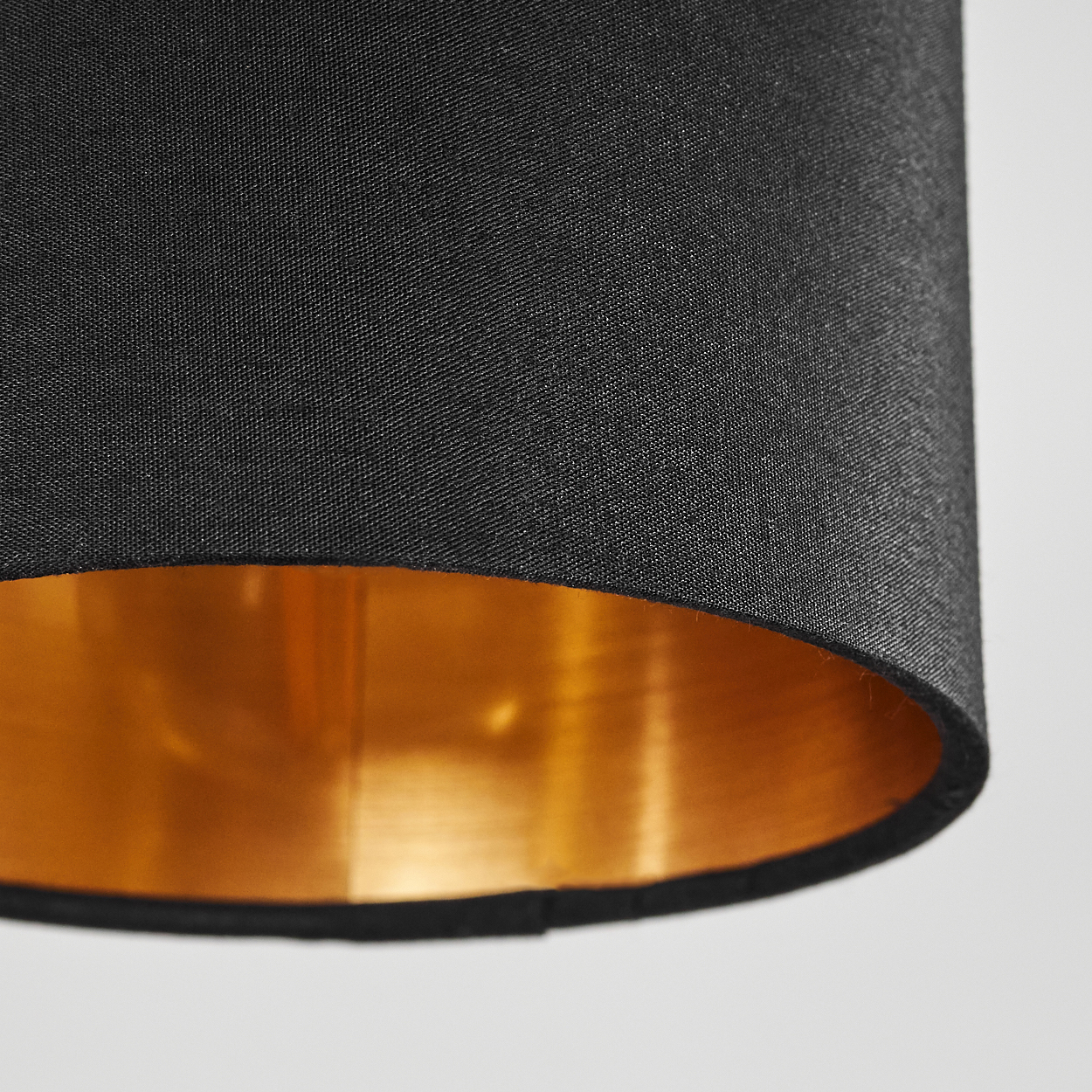 Nahaufnahme eines schwarzen Lampenschirms mit goldener Innenseite, der Textur und Details zeigt.