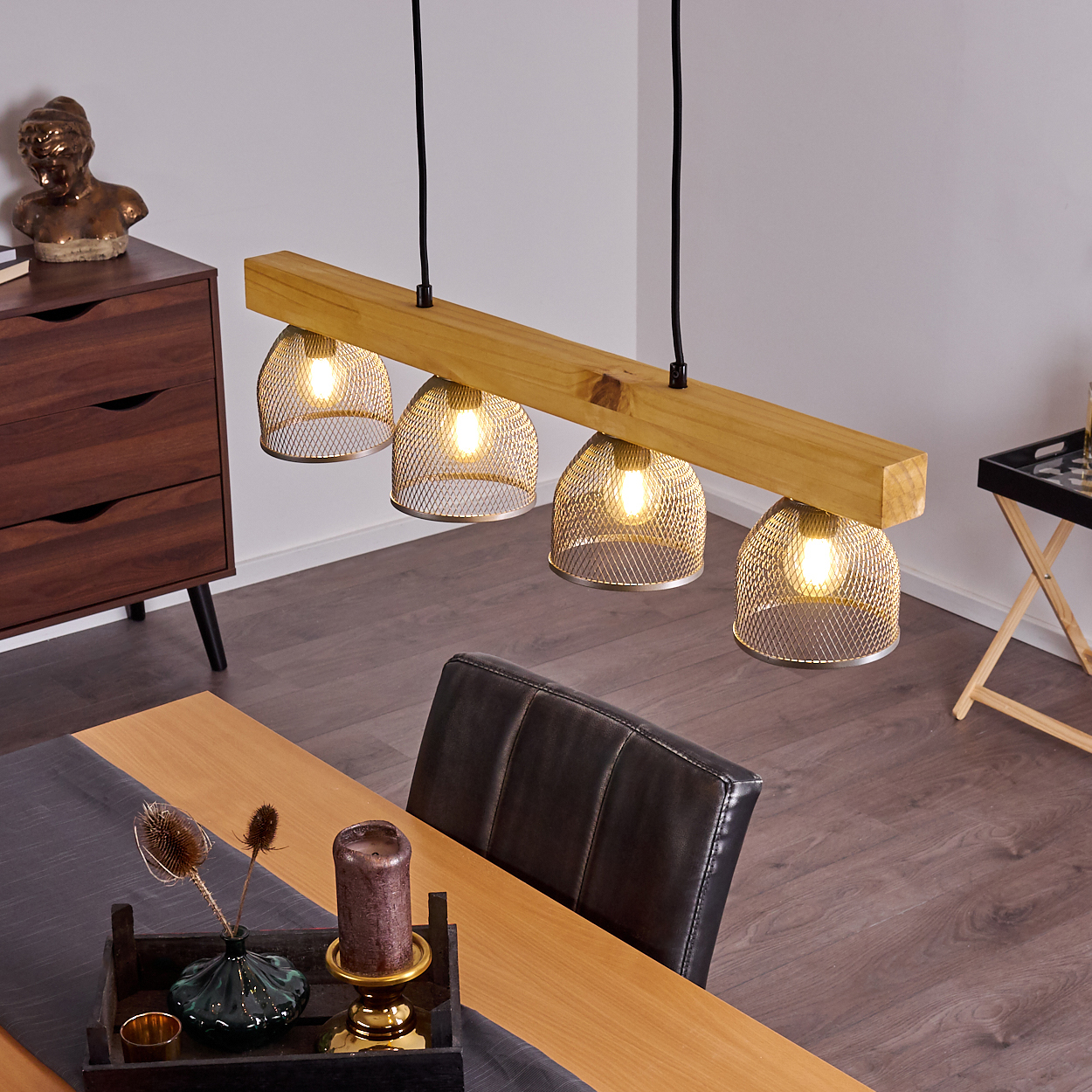 Esszimmer mit Holzbalken-Leuchte, vier Drahtgeflechtschirmen, Glühbirnen und Tischdeko.