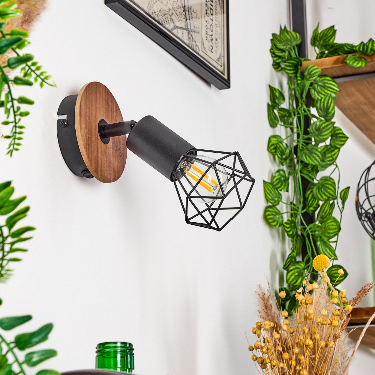 Wandlampe mit schwarzem Metallkäfig und Holzsockel. Hat einen modernen, industriellen Stil.