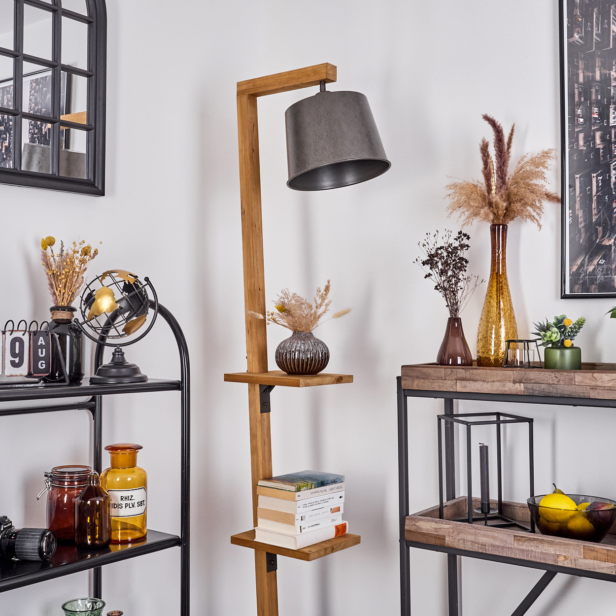 Wohnzimmerdekoration mit hölzerner Stehlampe, Regalen, Vasen und Dekorationsartikeln. Schwarzer Spiegel an der Wand.