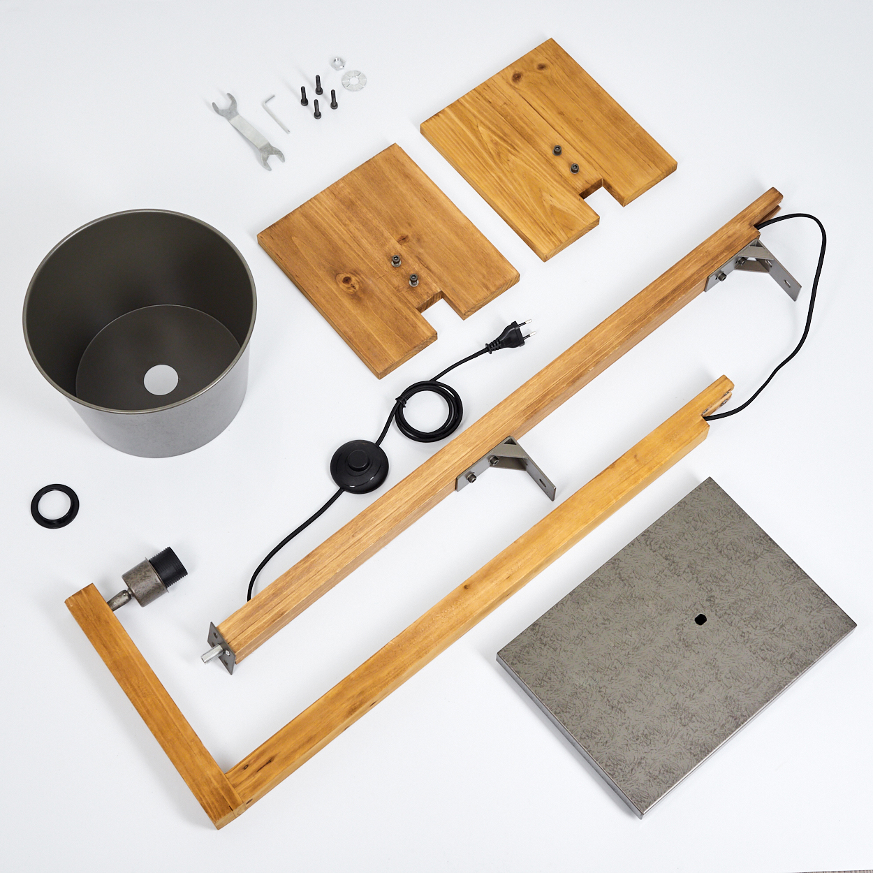 Zerlegte Teile einer Stehlampe, einschließlich Holzrahmen, Metallschirm und Werkzeug.