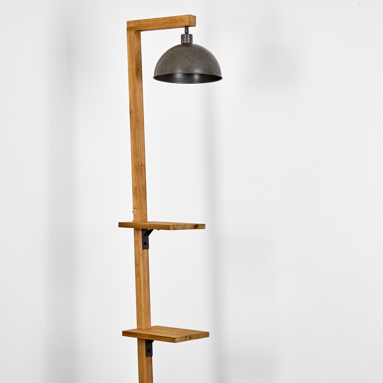 Stehlampe aus Holz mit Lampenschirm aus Metall und zwei Regalen.