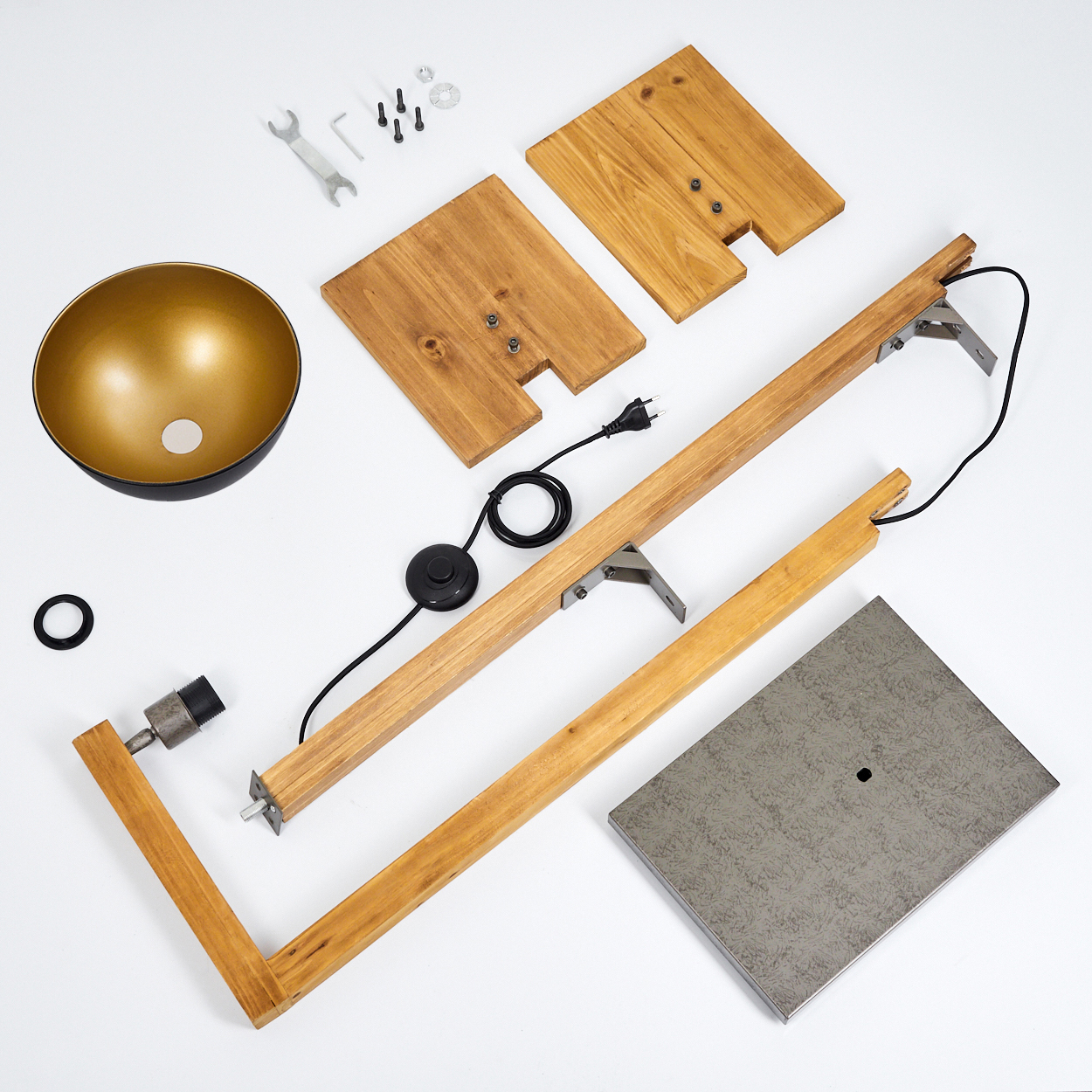 Eine Draufsicht zeigt zerlegte Lampenteile: Holzteile, ein Lampenschirm aus Metall, Schrauben und die elektrischen Komponenten der Lampe.
