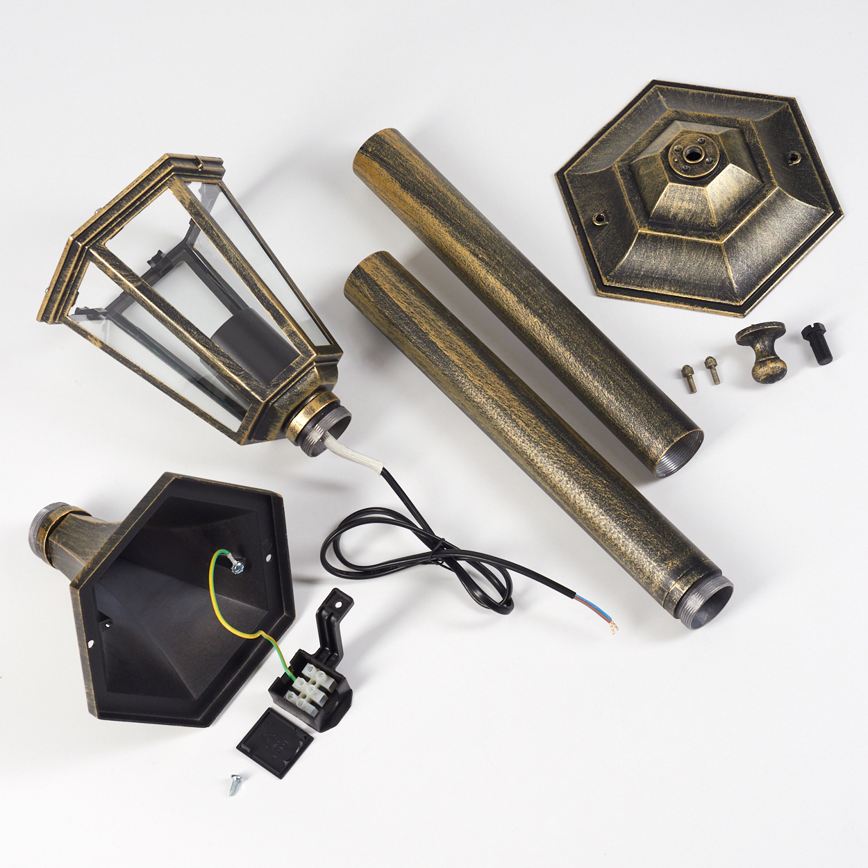 Die zerlegten Teile einer Außenlampe werden ausgestellt, darunter ein Lampenkopf, Stangen, ein Sockel und elektrische Komponenten.