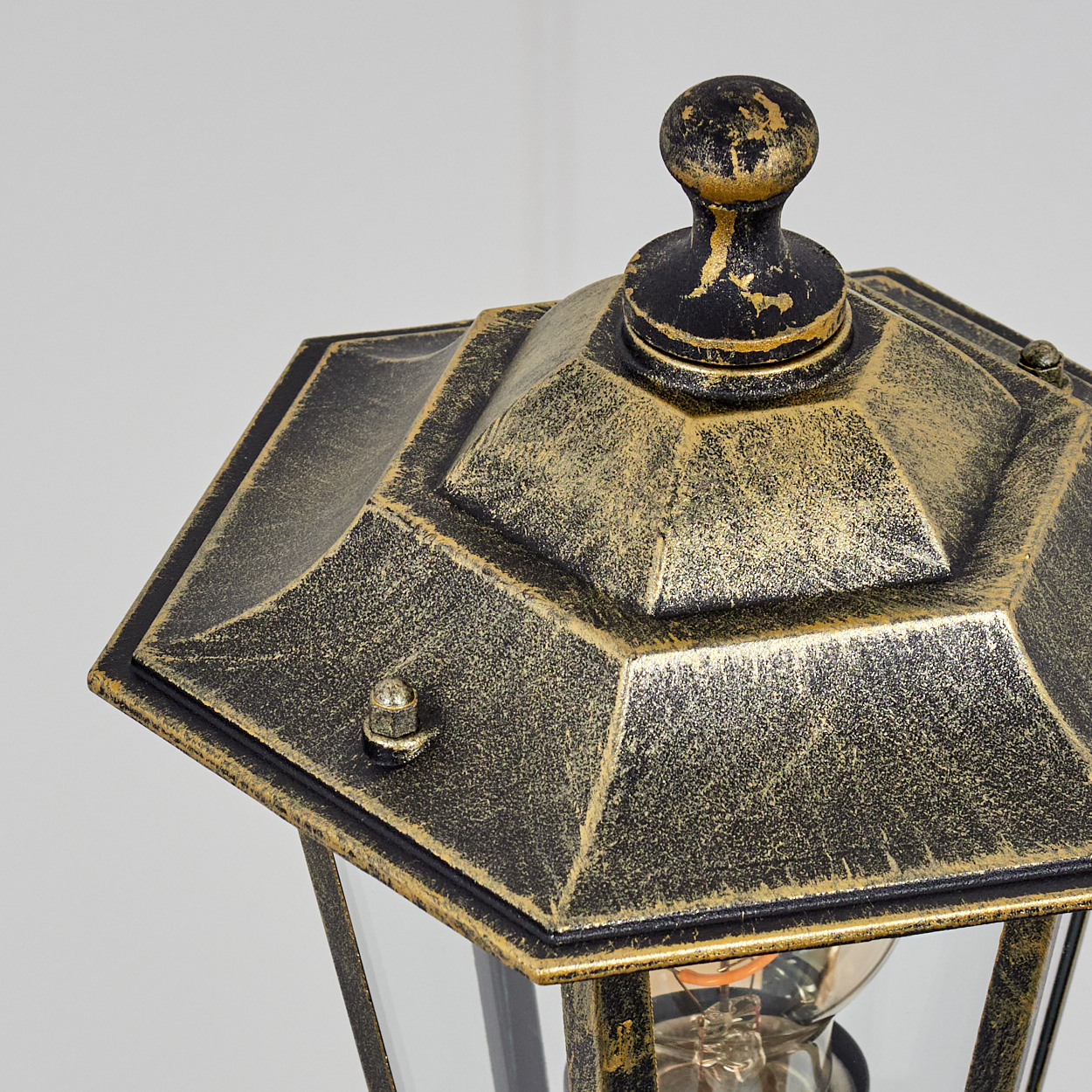 Nahaufnahme einer Vintage-Außenlampe. Die Lampe hat eine goldene Oberseite.