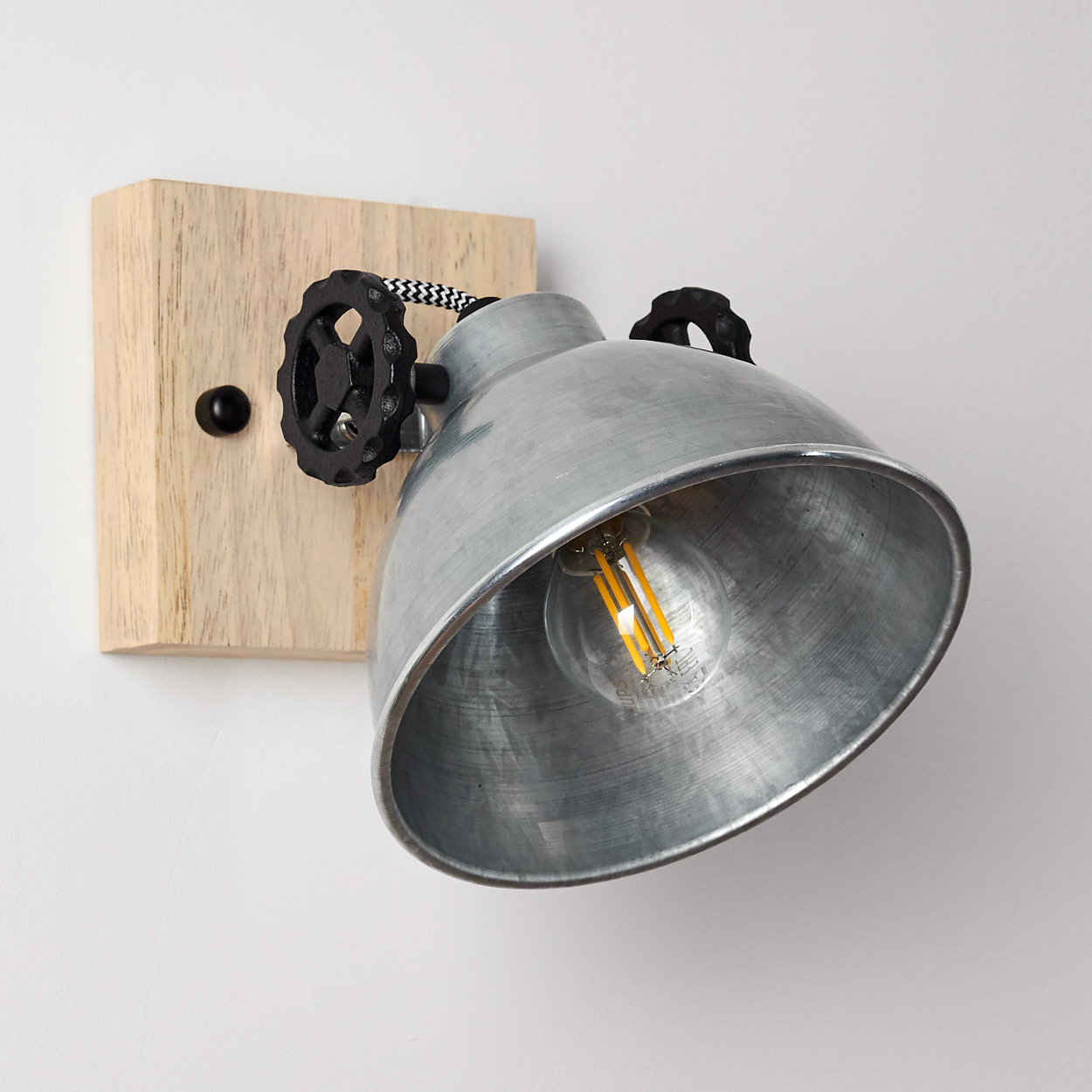 Industrielle Wandlampe mit Holzsockel und Metallschirm, auf weißem Hintergrund.
