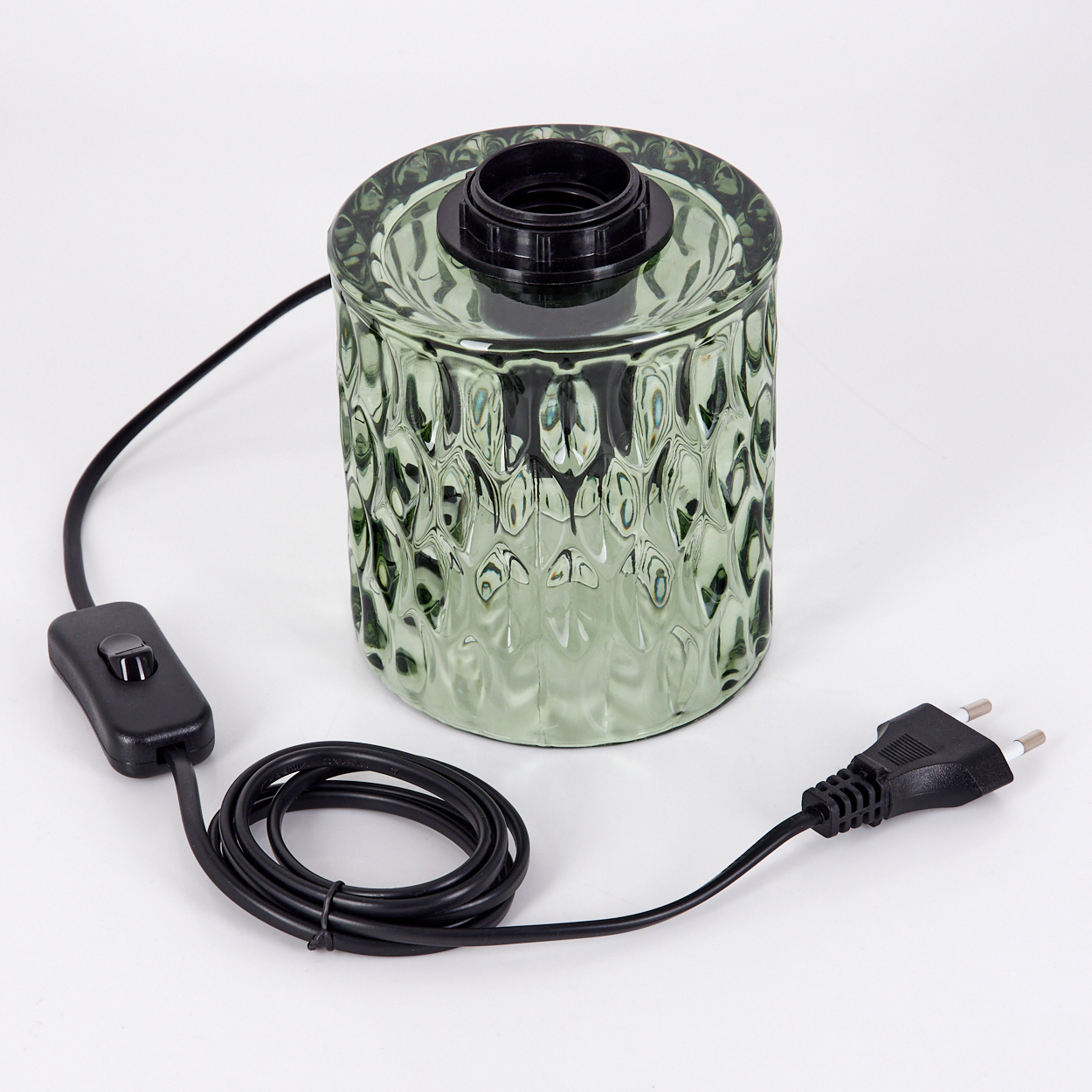 Grüne Glaslampenbasis mit schwarzem Schalter und Stecker, Kabel aufgerollt.